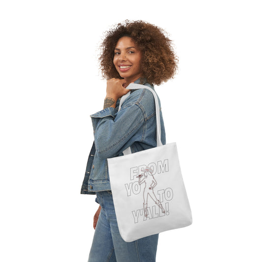 Woman carrying a white tote bag featuring a line drawing of a figure with a microphone and the text "FROM YOU TO Y'ALL!"