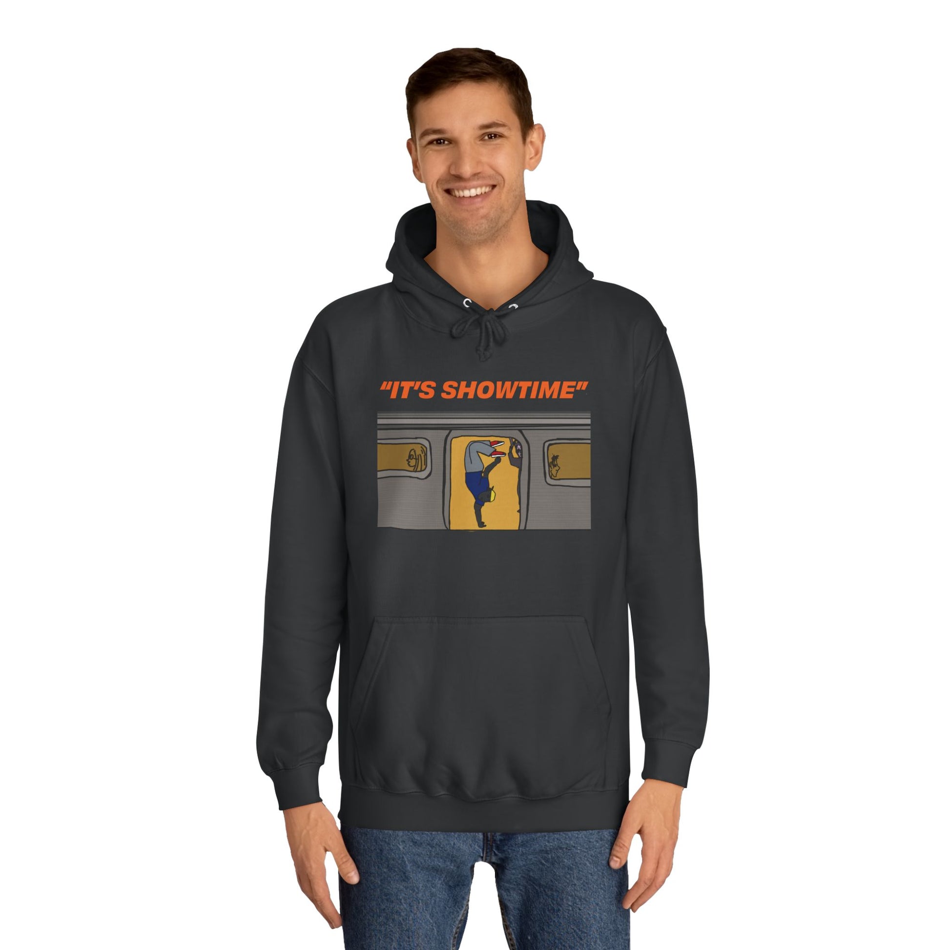 Smiling male model wearing black It’s Showtime Hoodie with subway performer artwork on front.