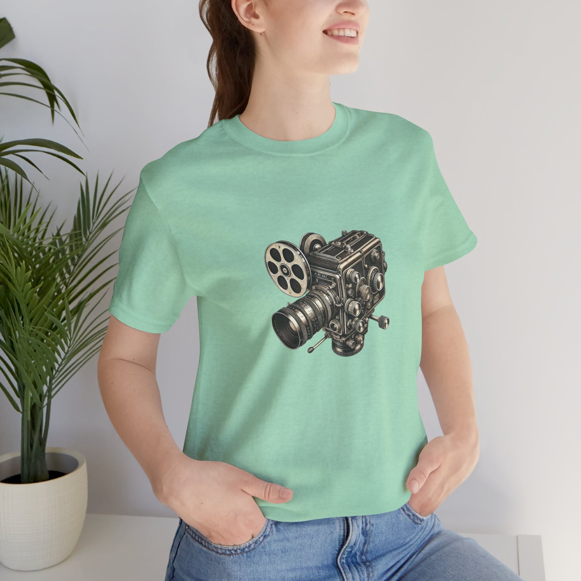 Woman wearing light green t-shirt with vintage 16mm camera design indoors