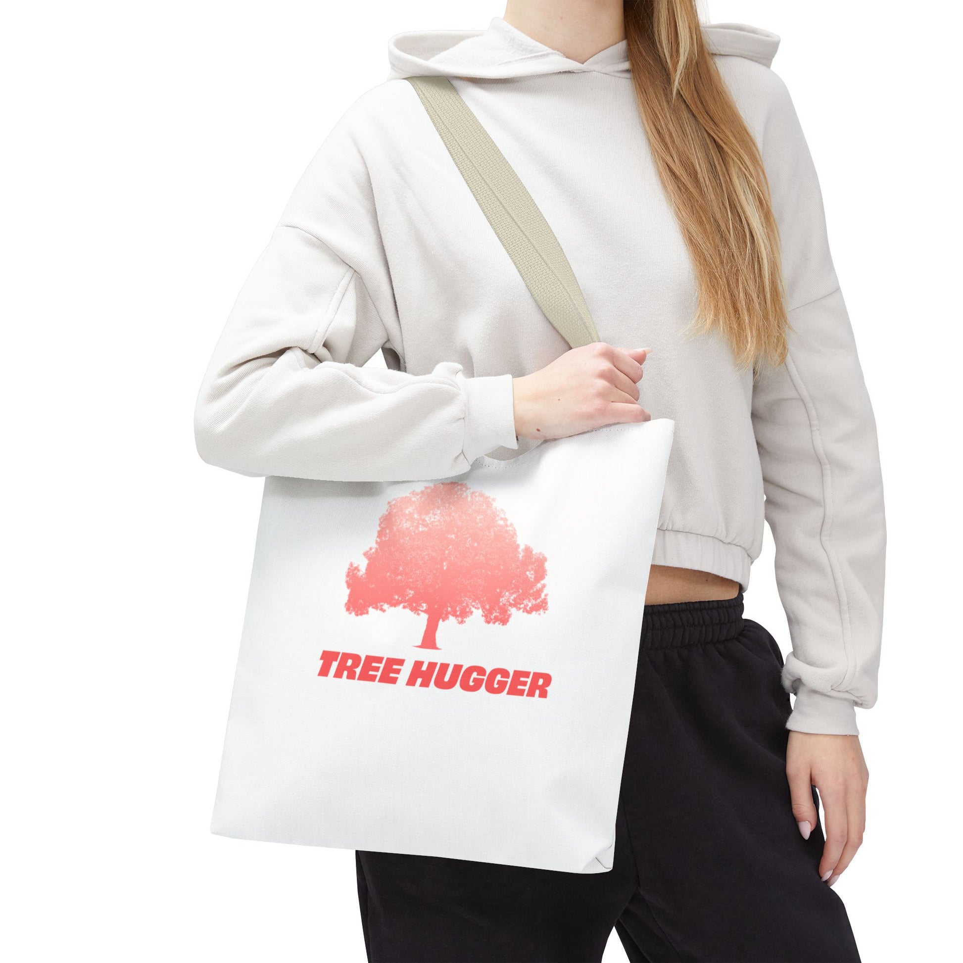 Woman wearing cap carrying Tree Hugger Tote Bag with red tree graphic