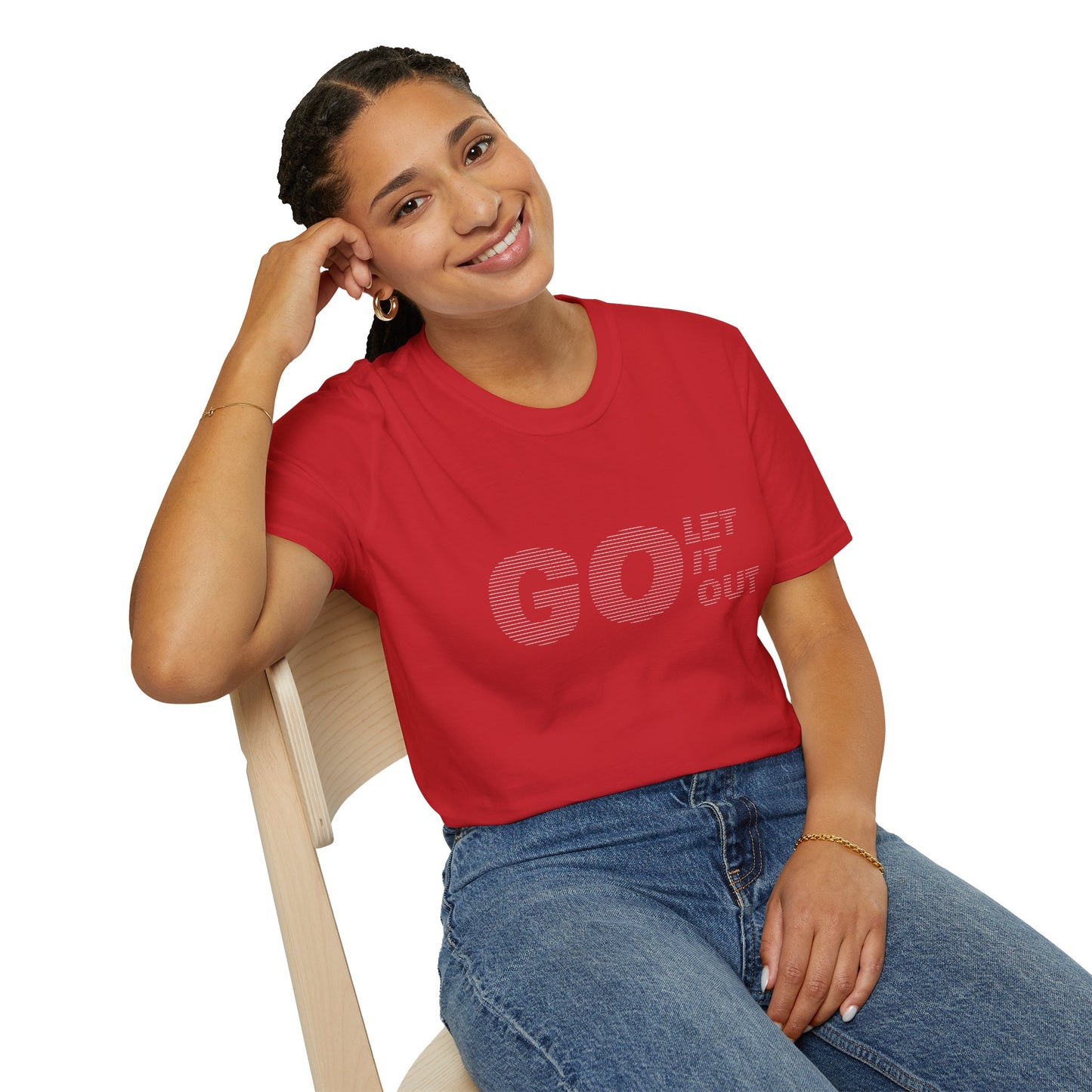 Woman sitting on chair, smiling, wearing red Oasis Go Let It Out stencil t-shirt.