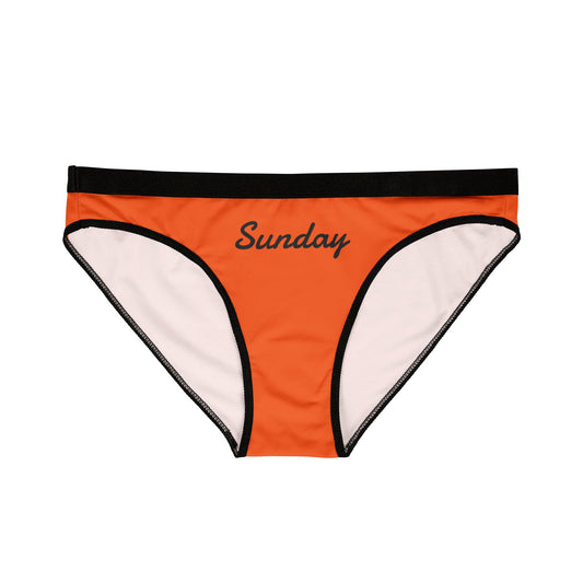 Front view of Sunday Panty in orange with black waistband and black “Sunday” text