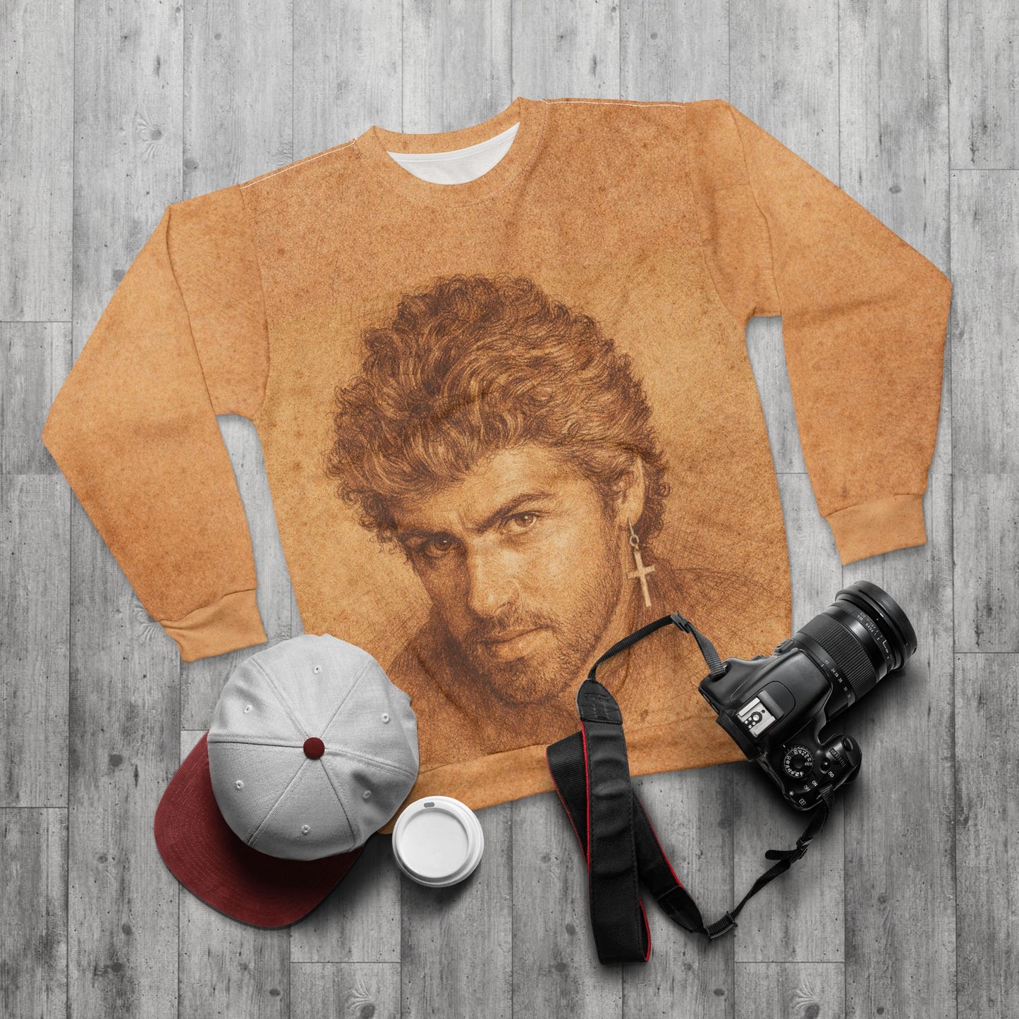 Styled flat lay of George Michael portrait sweatshirt with camera and accessories