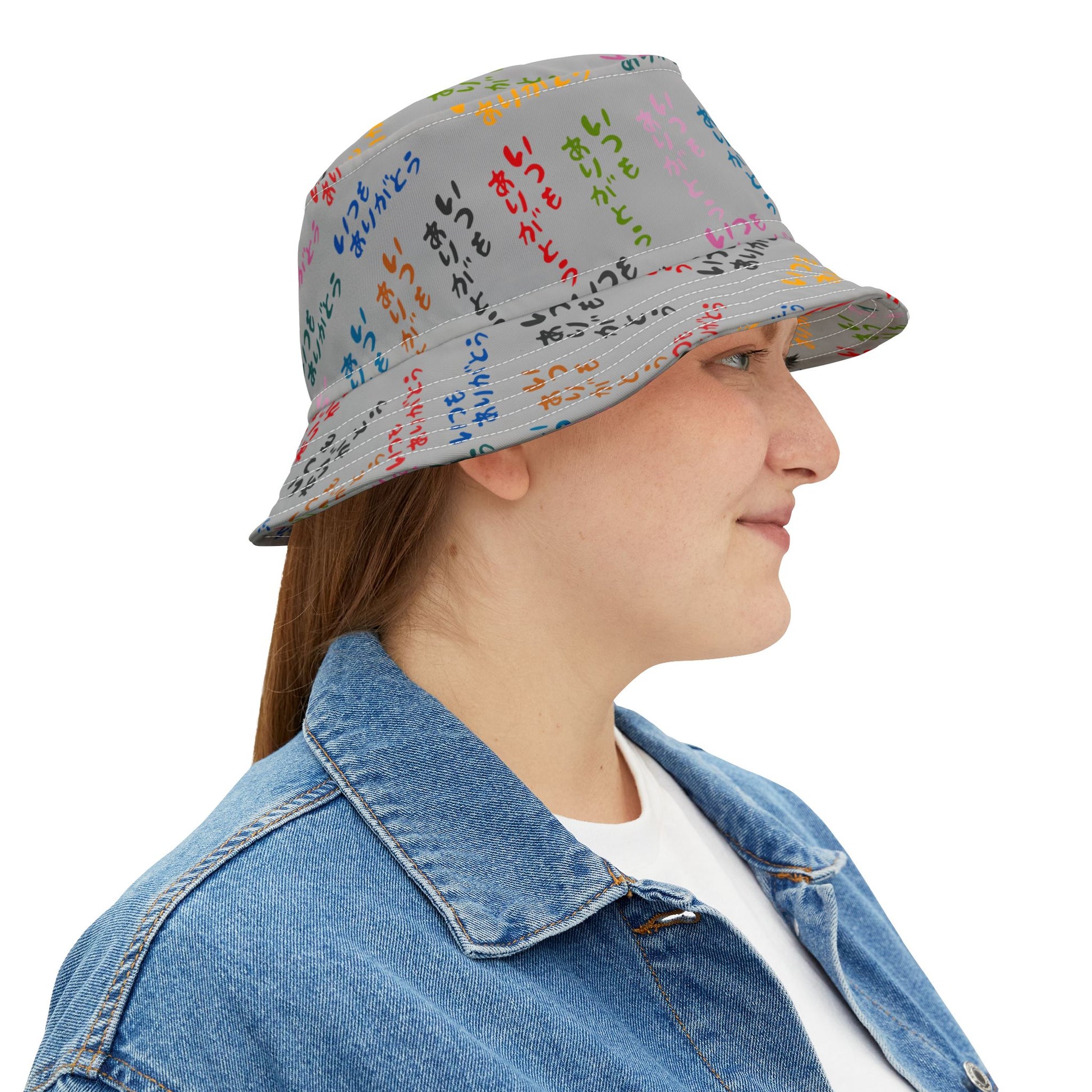 Woman wearing Japanese Text Bucket Hat with multicolor text design, smiling slightly.