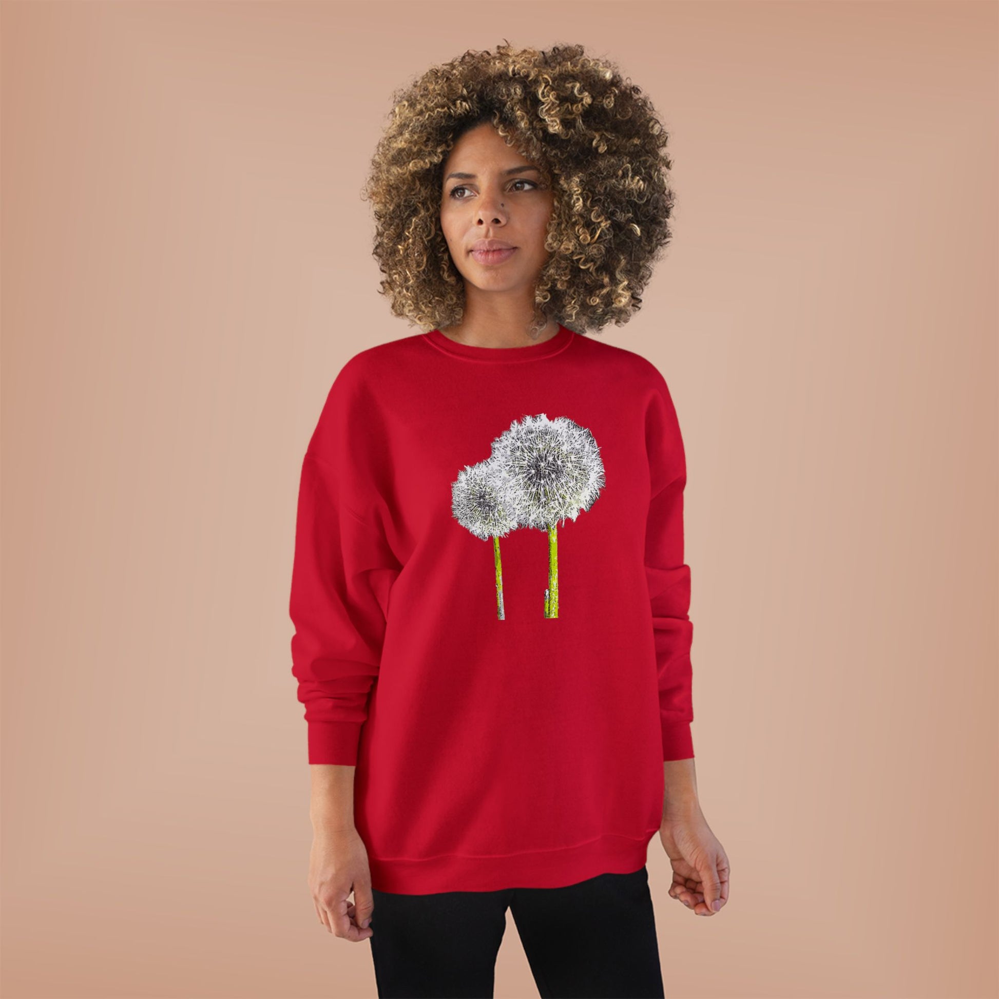 Woman in red Tantrum Media Dandelion Unisex Sweatshirt with white dandelion print, peach background