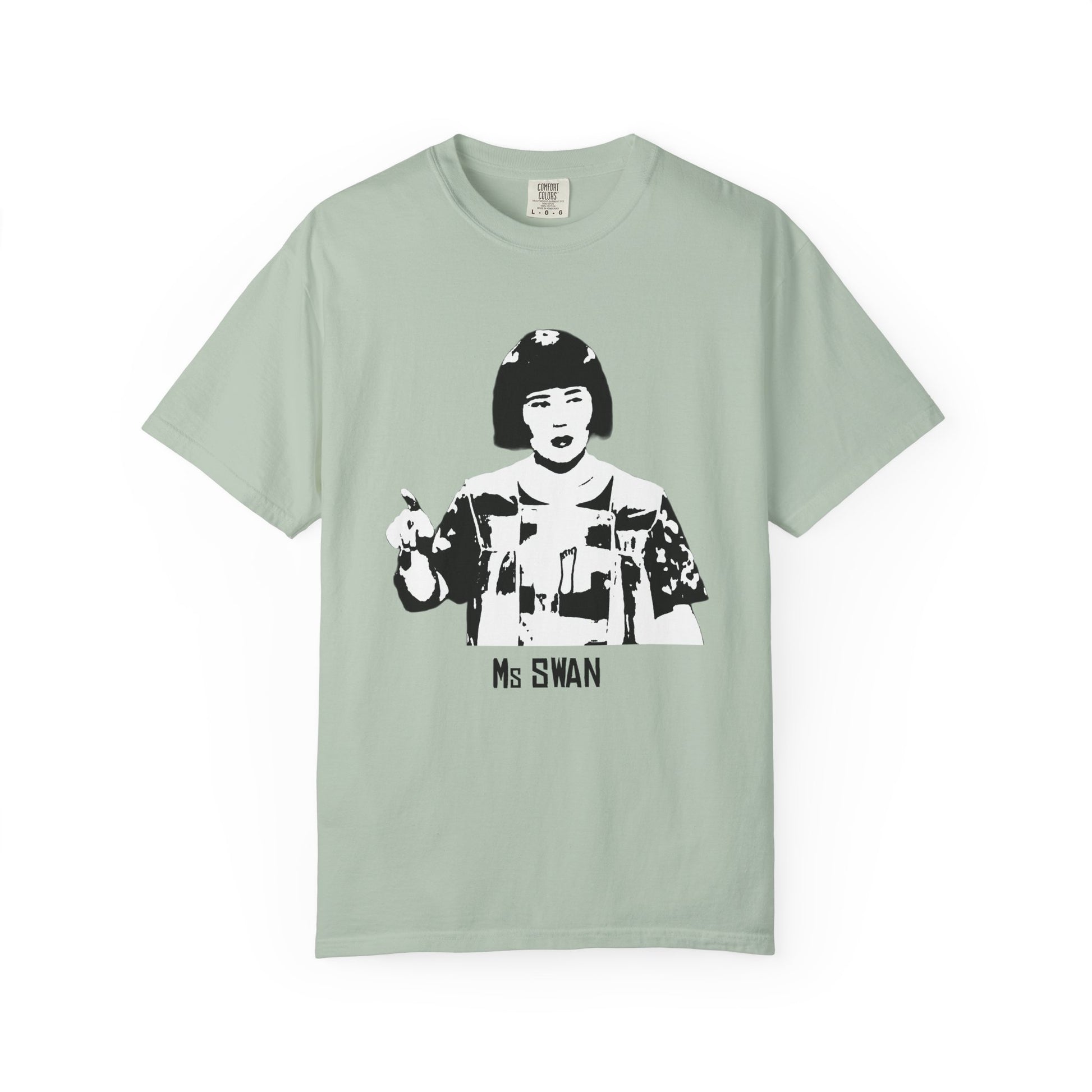Light sage green Ms. Swan T-shirt laid flat with black-and-white character design.