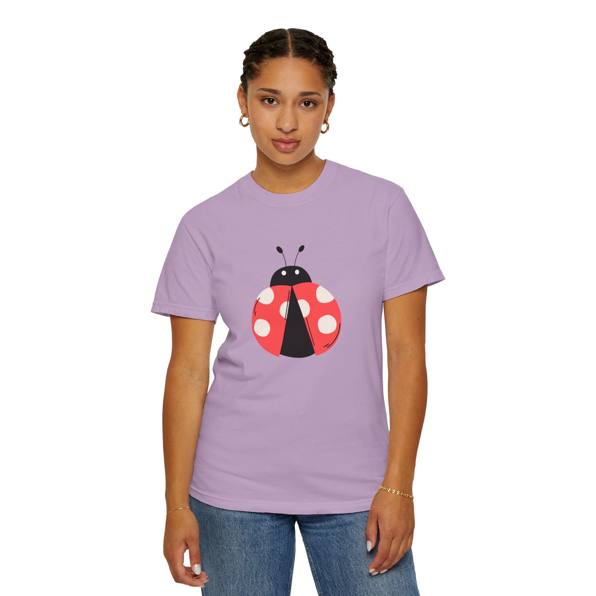 Woman in lavender Lady Bug T-Shirt with lady bug graphic, standing.
