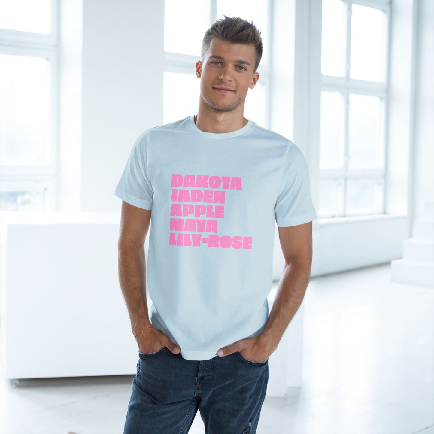 Man wearing a light blue t-shirt with pink text in a bright room