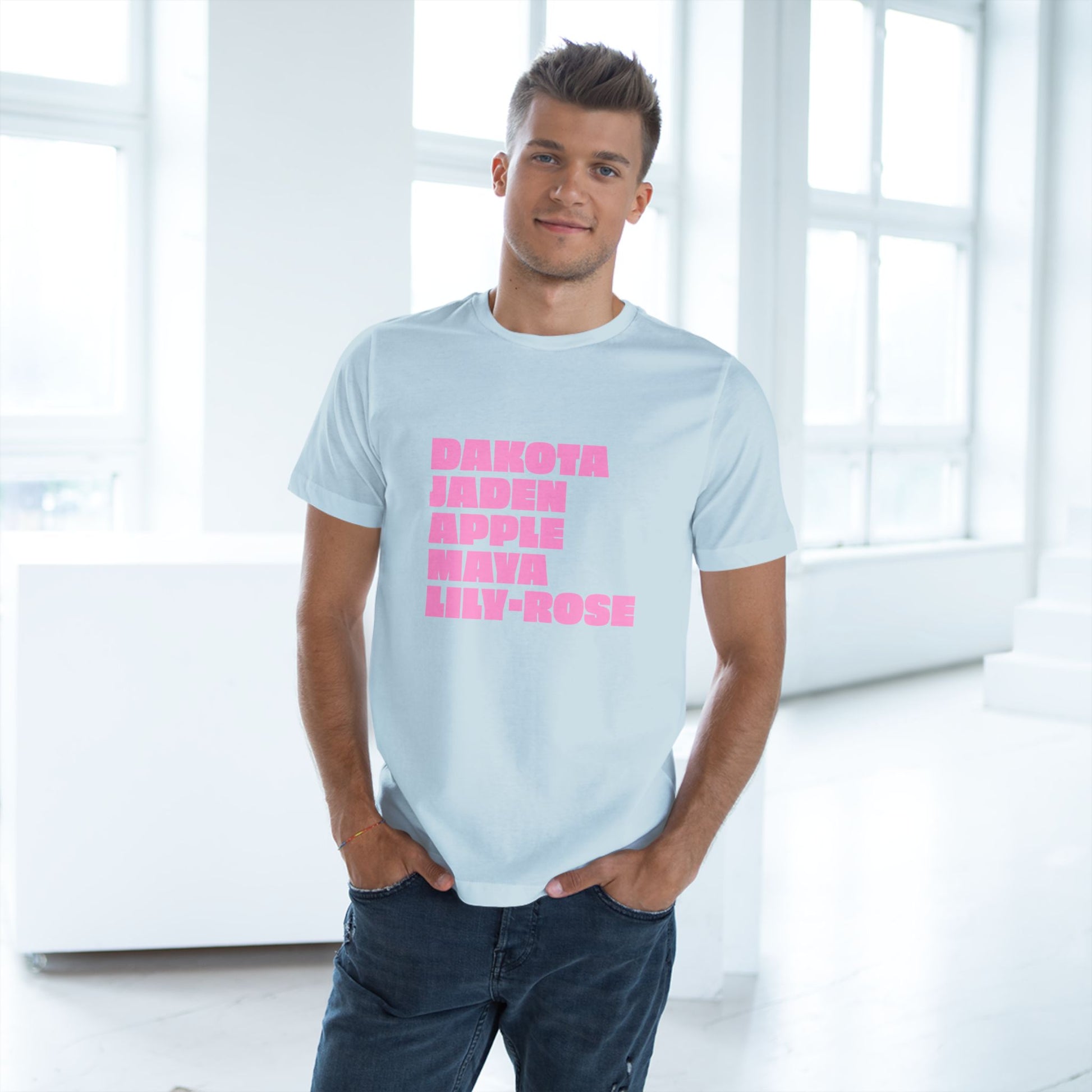 Man wearing a light blue t-shirt with pink text in a bright room