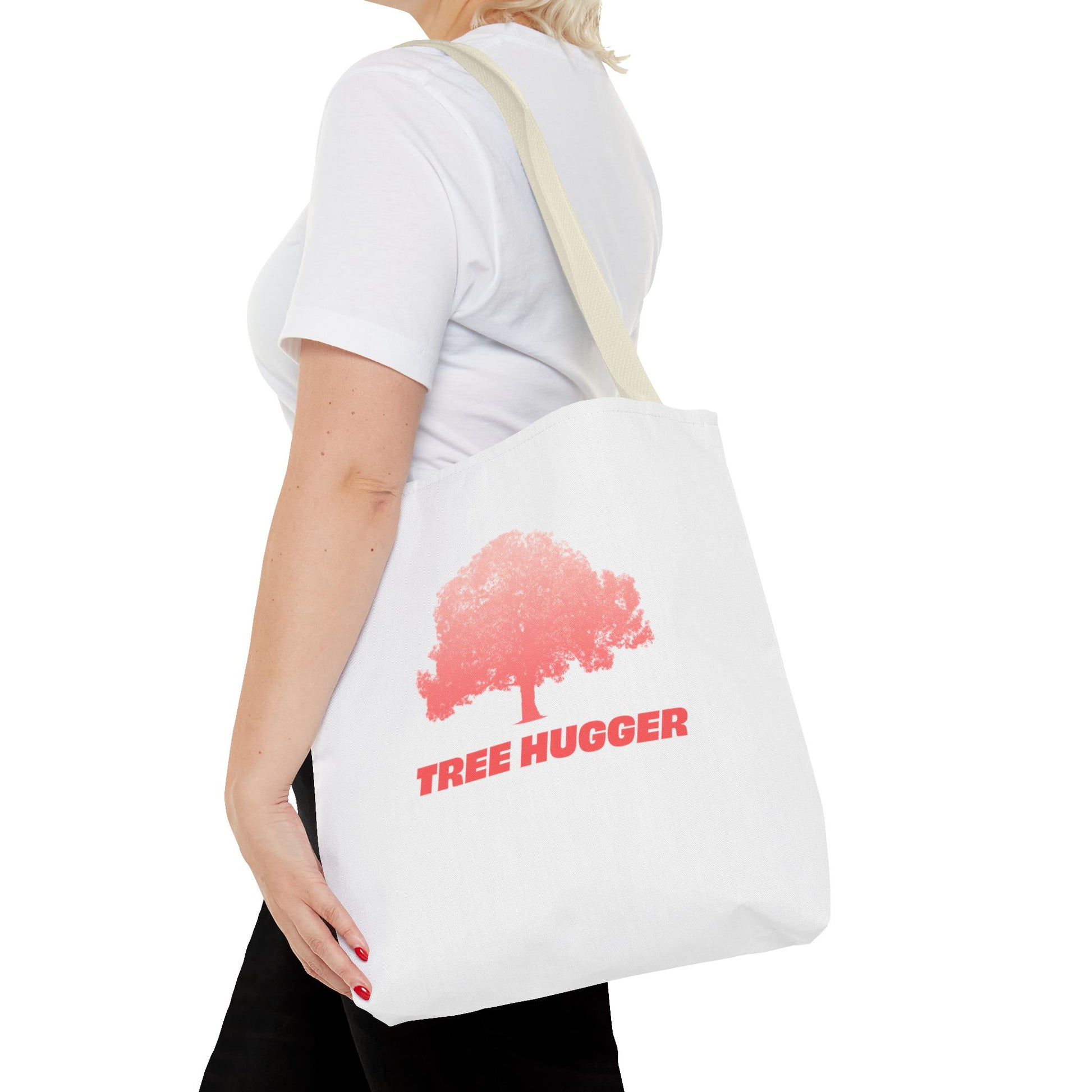 Woman carrying Tree Hugger Tote Bag over shoulder with red tree graphic