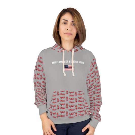 A person wearing a gray unisex hoodie that says "Make America Healthy Again" above an American flag graphic, featuring red floral patterned sleeves and front pocket, standing against a white background.