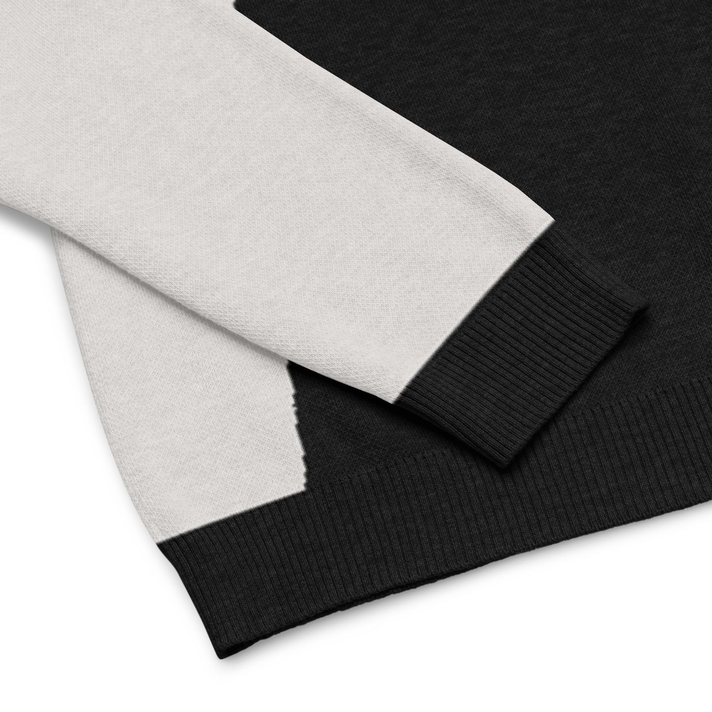 Close up of the sweater’s cuff, hem, and cat graphic showing knit detail.