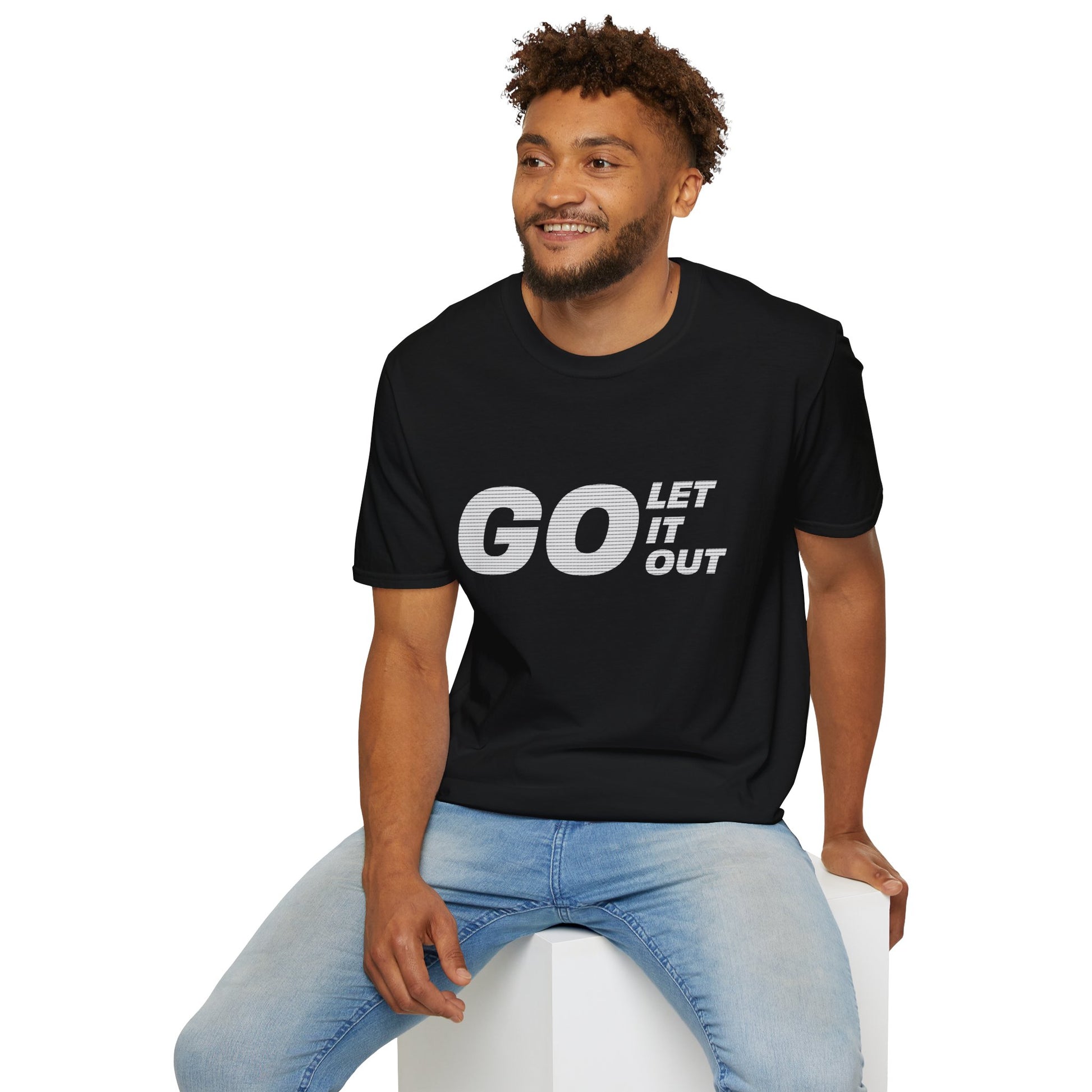 Man wearing black Oasis Go Let It Out T-shirt, sitting on stool