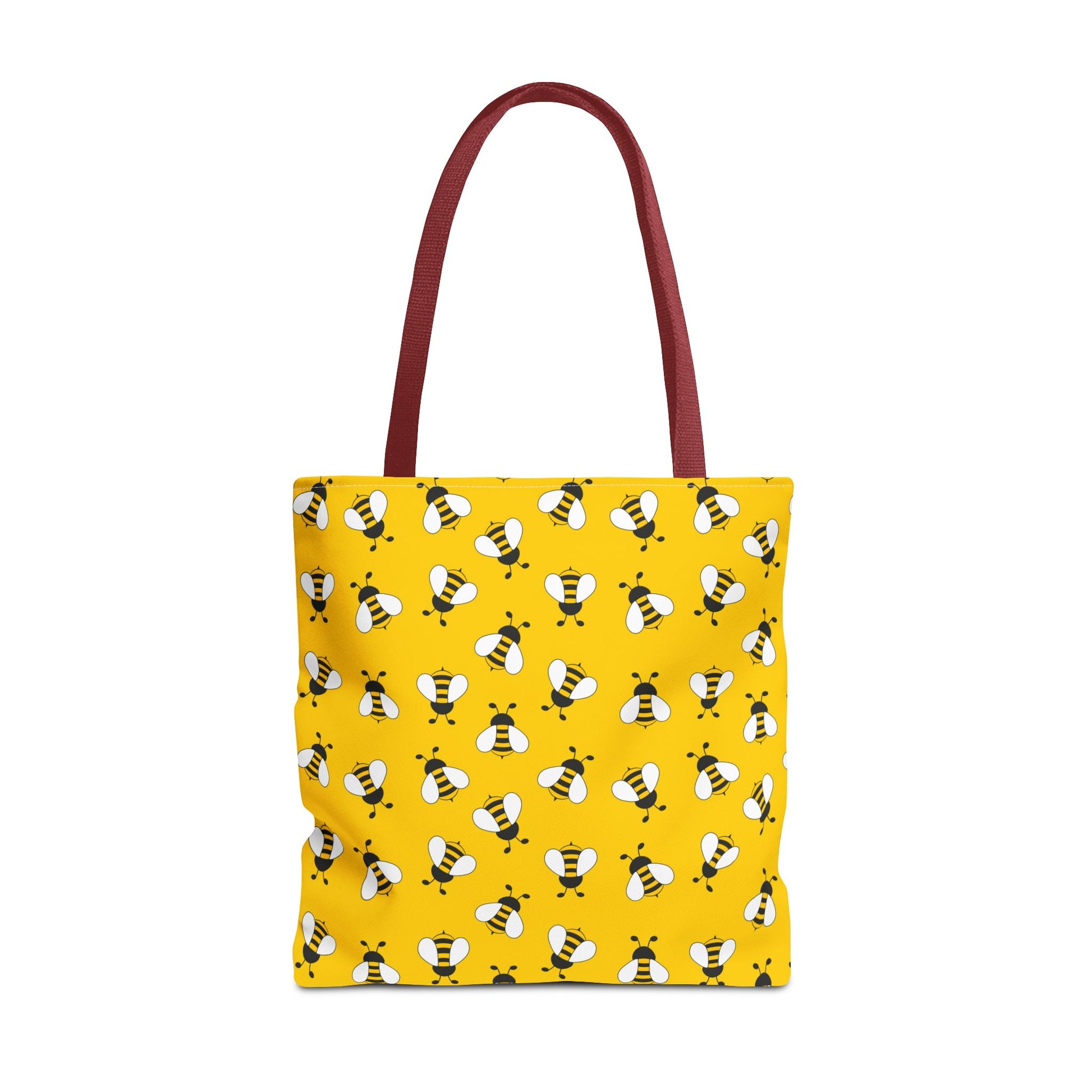 Yellow tote bag with bee pattern and red handle on a white background