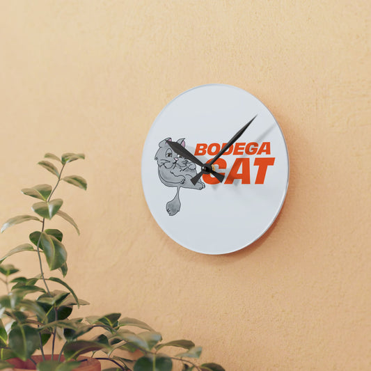 Wall clock with 'Bodega Cat' design on a beige wall with a plant in the foreground