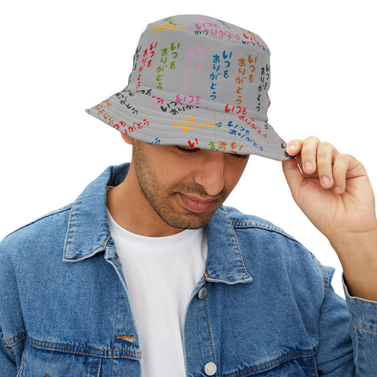 Man wearing Japanese Text Bucket Hat with colorful Japanese characters, holding brim while looking down.