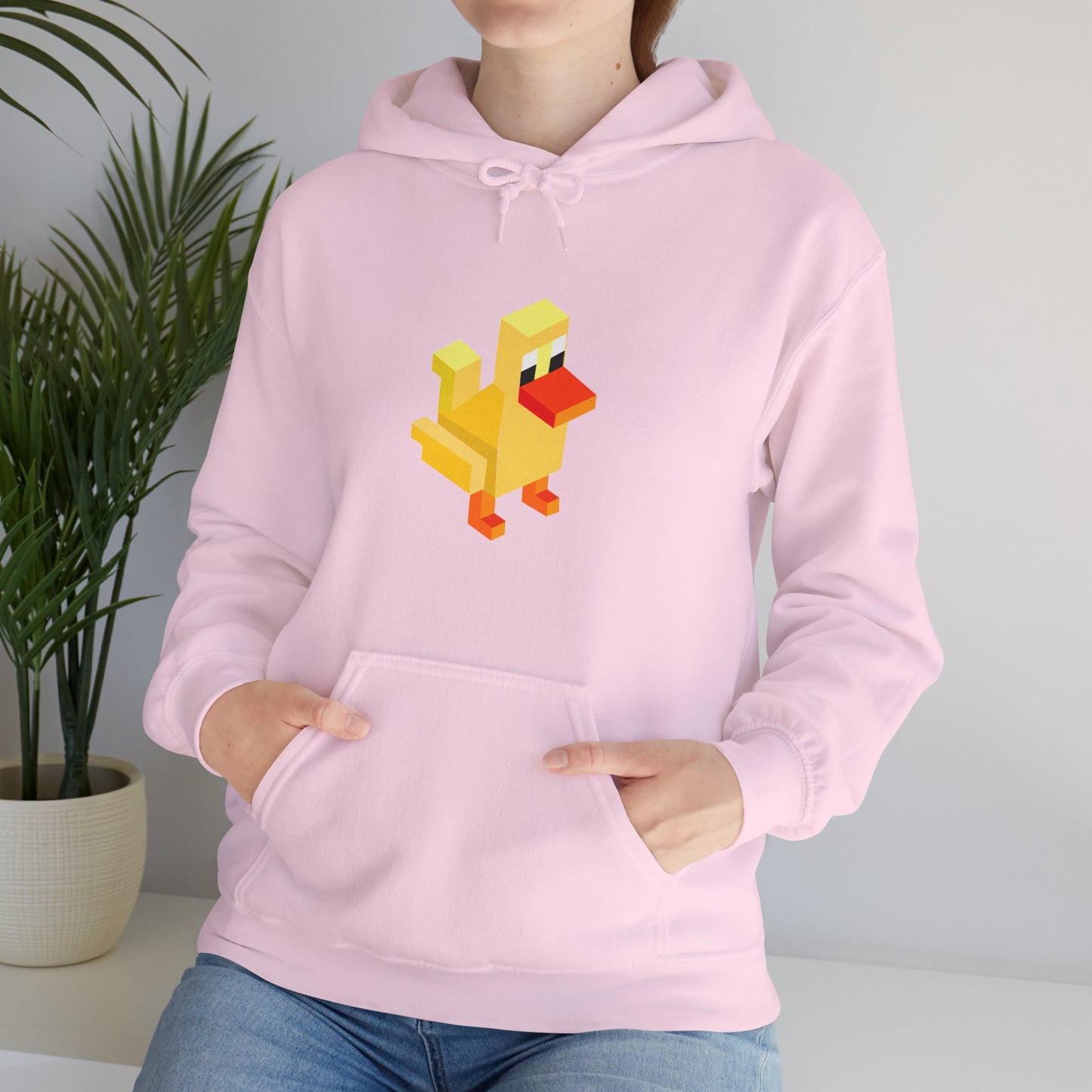 Woman wearing light pink pixel duck hoodie, cute retro gaming streetwear unisex sweatshirt