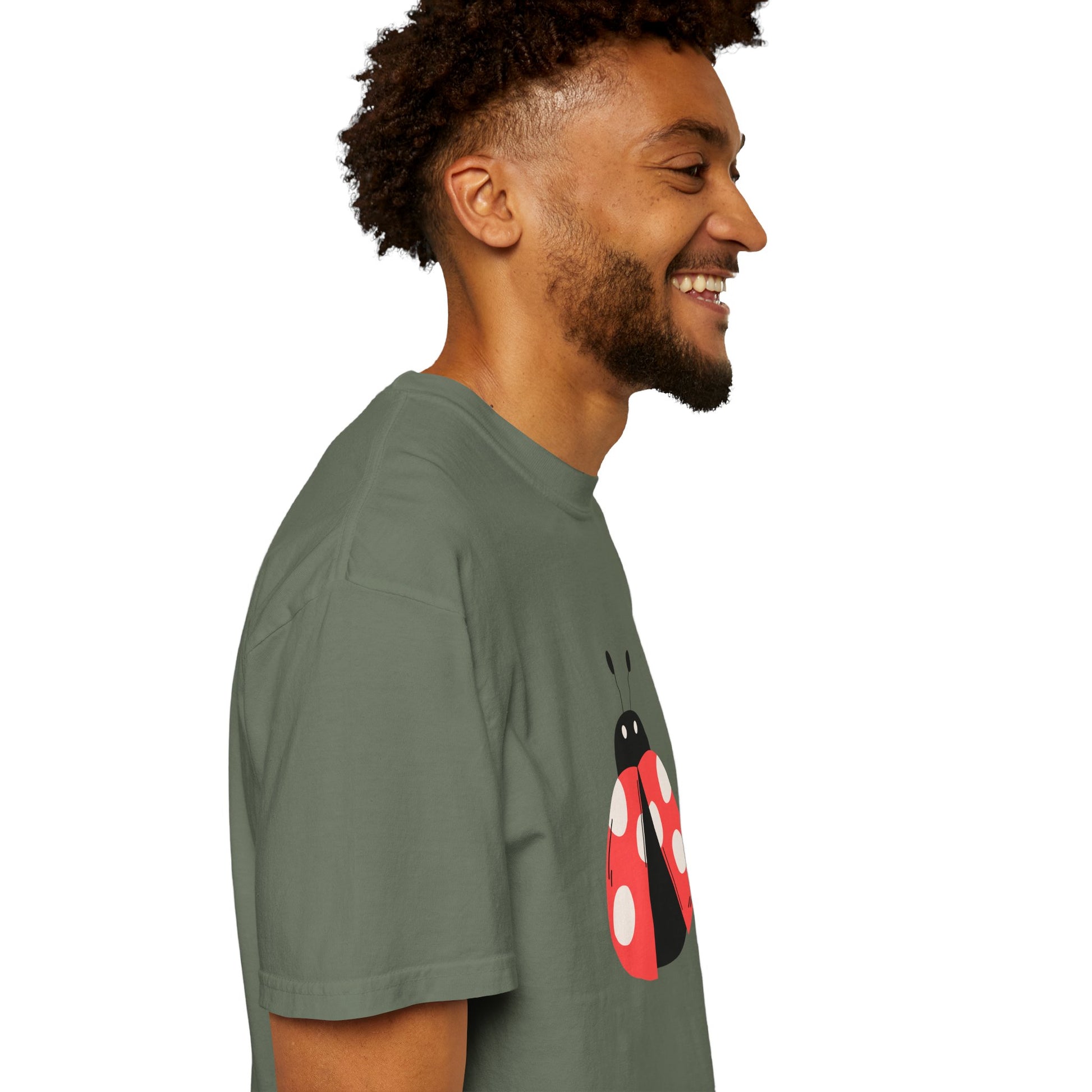 Side view of man wearing olive green Lady Bug T-Shirt, smiling.