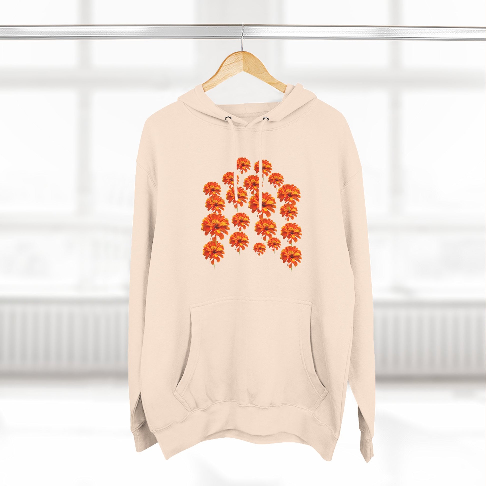 Cream Zinnia Hoodie on a hanger with orange flower design