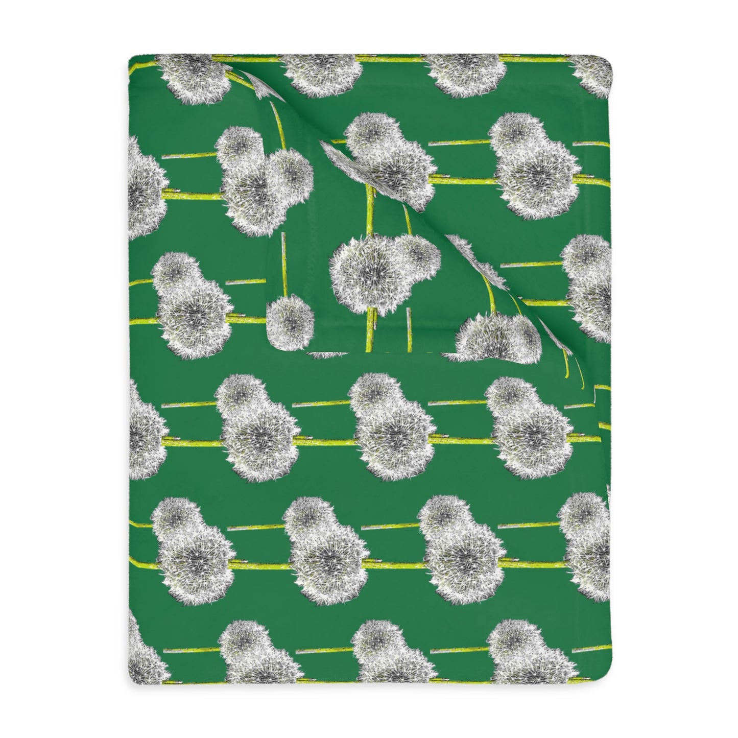 Close-up of folded green blanket showing white dandelion pattern