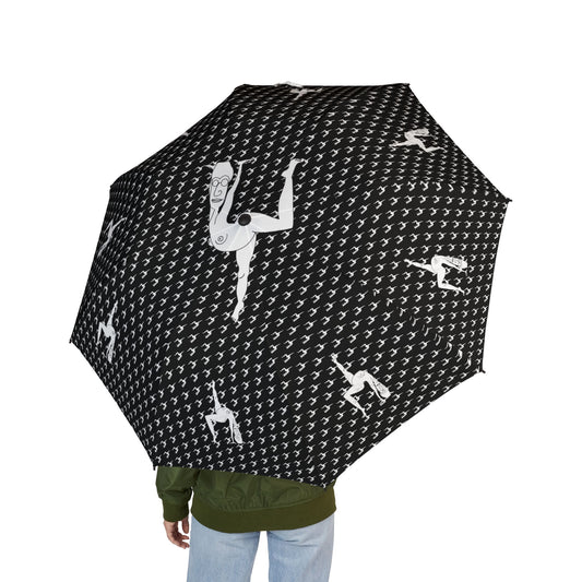 Person holding a black Elastika Umbrella with white hand-drawn dancing figures