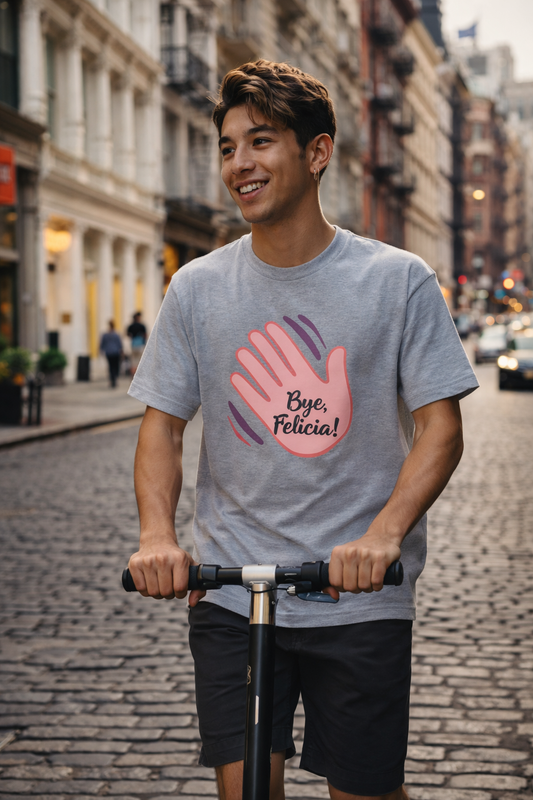 Man wearing the Bye Felicia! T-Shirt in gray while riding a scooter on a city street, showcasing a relaxed casual outfit.