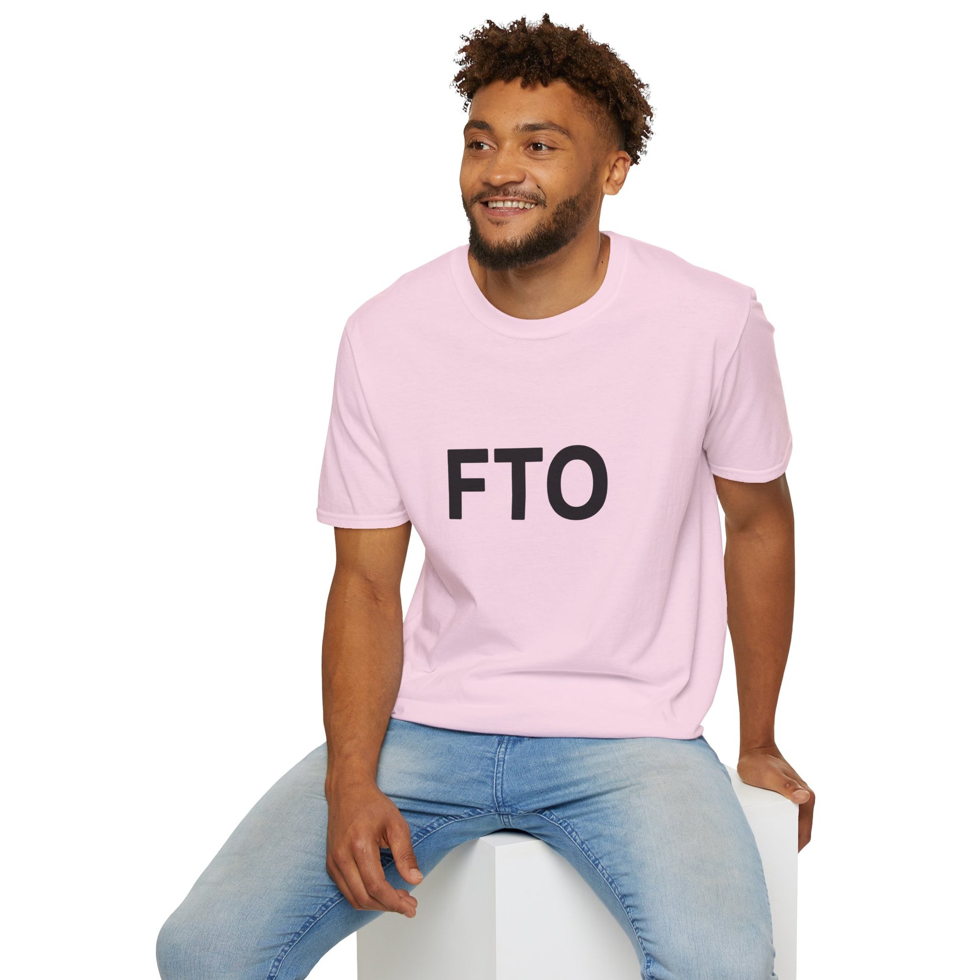 Man wearing a pink t-shirt with 'FTO' text sitting on a white stool against a white background