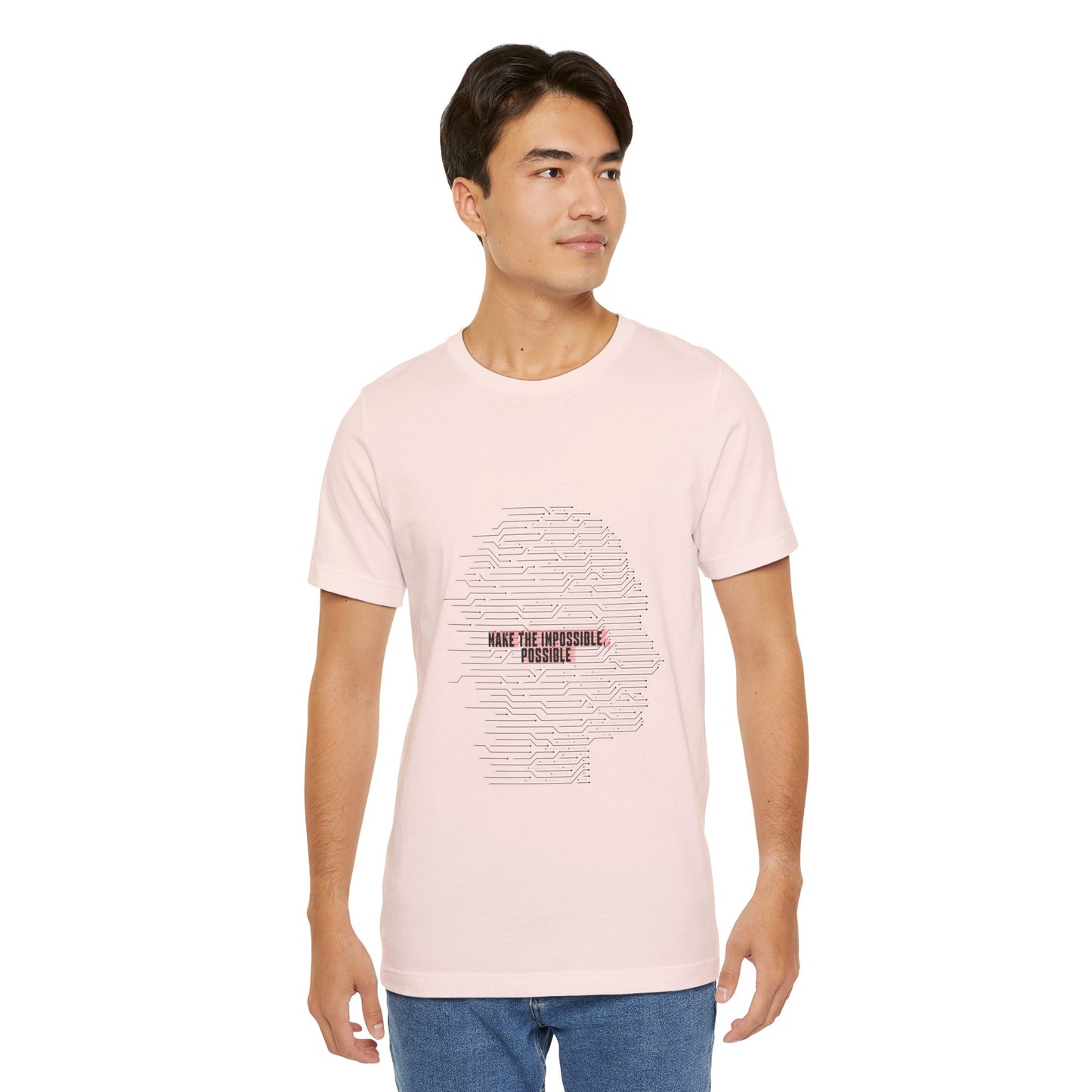 Man in pastel pink Make It Possible T-Shirt standing casually.