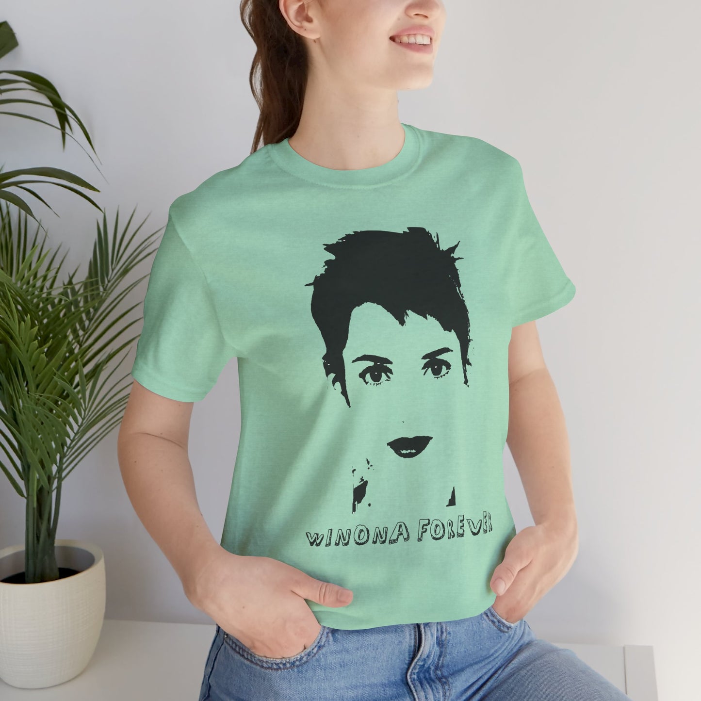 Woman wearing mint green Winona Forever T-shirt featuring minimalist portrait graphic.