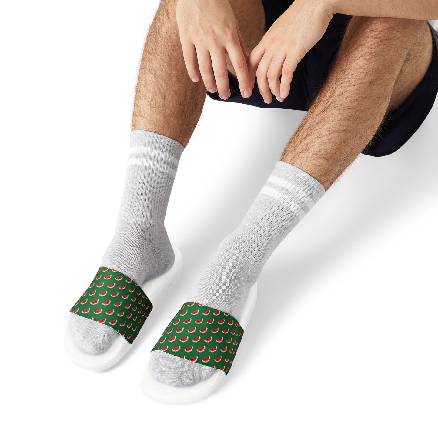 Man seated wearing Watermelon Green Slide Sandals with patterned straps styled with socks.