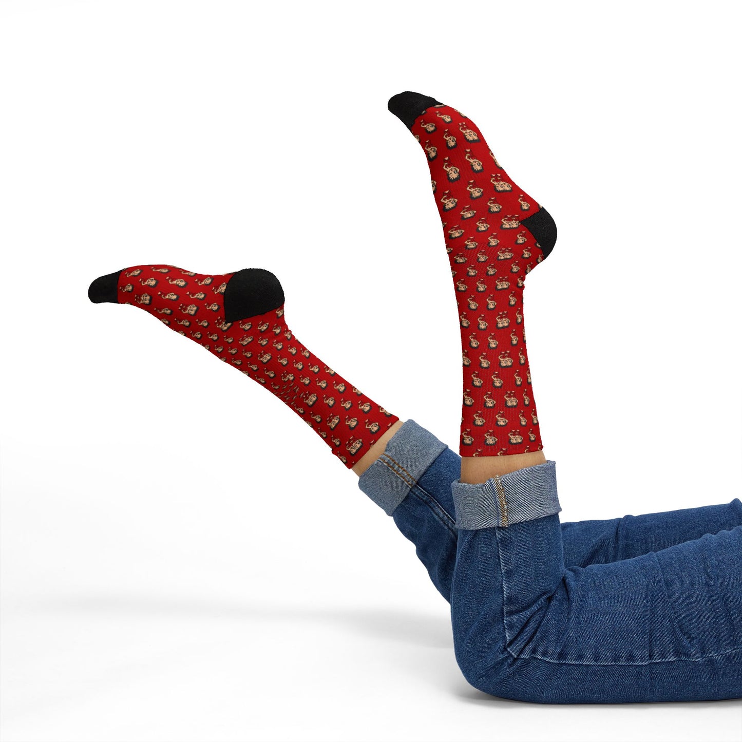 Person lying down with legs raised wearing red Betty Boop pattern crew socks and denim jeans