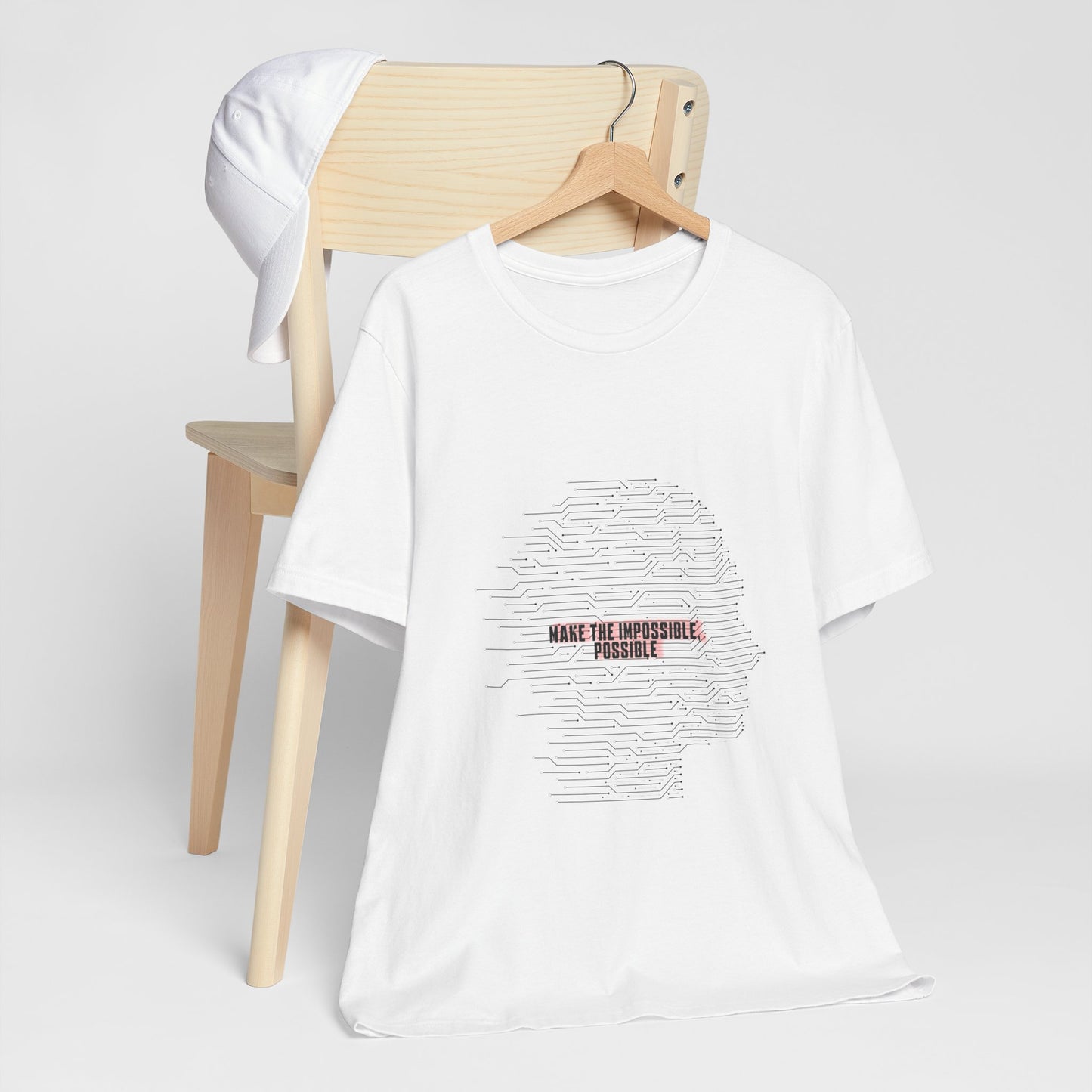White Make It Possible T-Shirt on chair with empowering design.