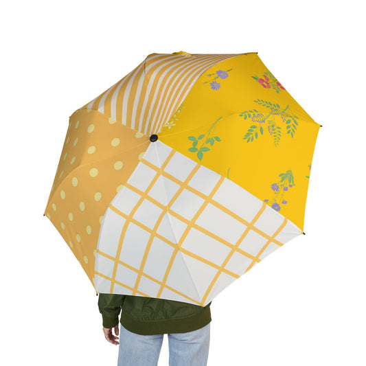Person holding colorful patchwork umbrella with polka dots, stripes, florals, and grid patterns.