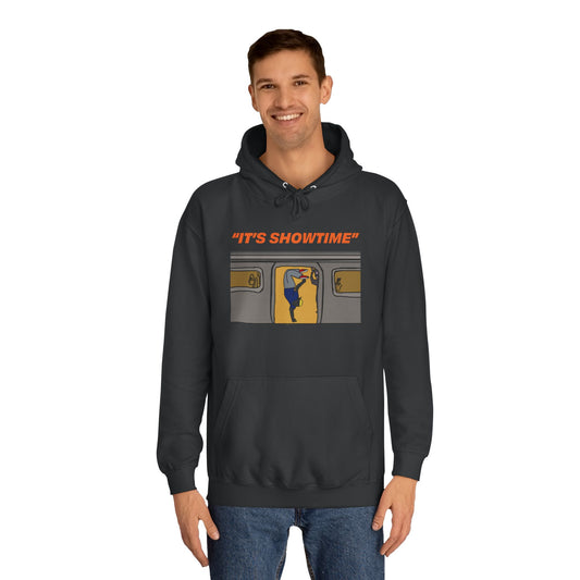 Smiling male model wearing black It’s Showtime Hoodie with subway performer artwork on front.