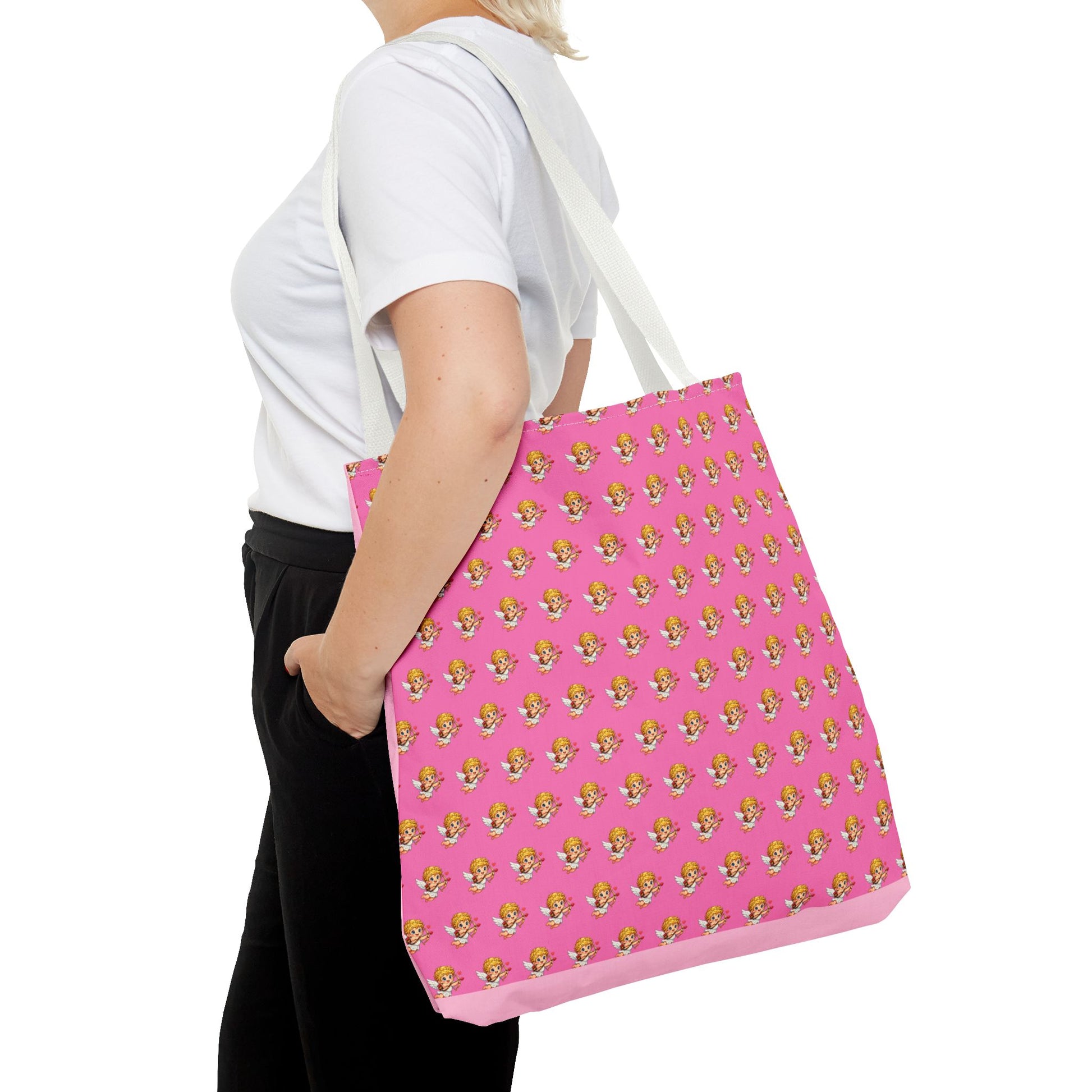 Person holding a pink tote bag with a pattern, wearing a white shirt and black pants on a white background