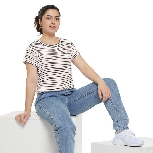 Woman wearing a striped t-shirt and jeans, seated casually on a white block.