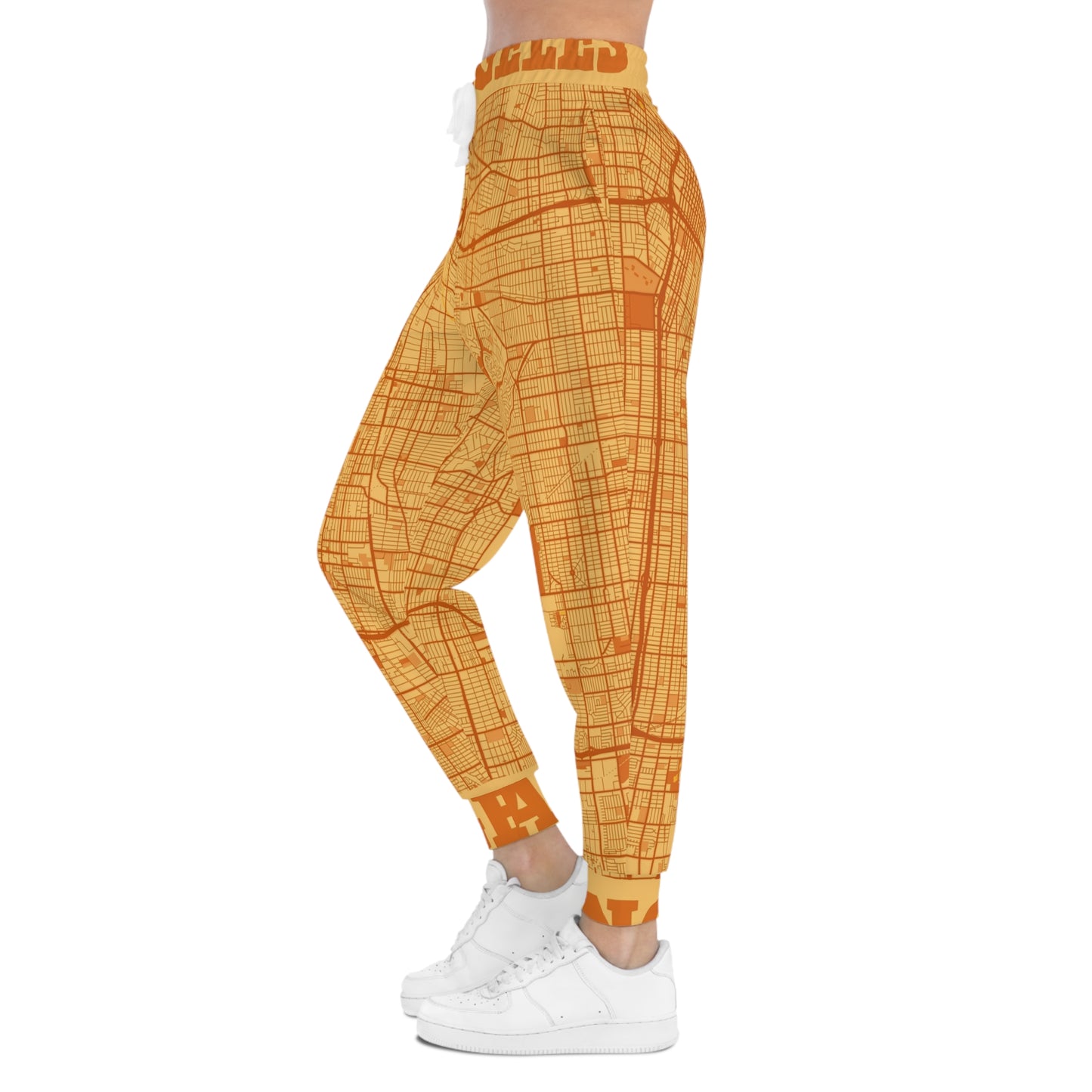 Side view of orange Los Angeles map print joggers on a model highlighting leg fit and pattern.
