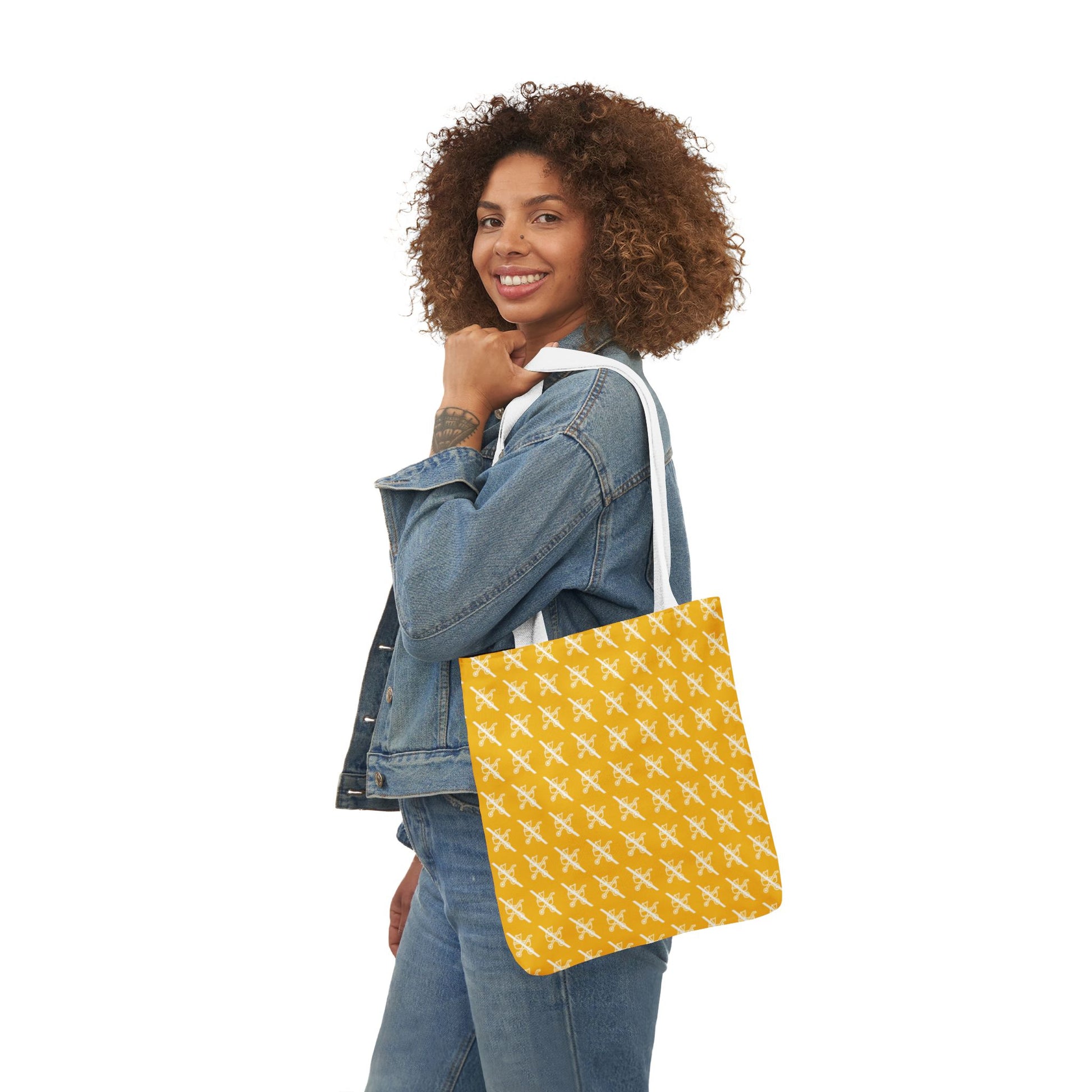 Model in denim outfit smiling while holding Proudly Childless yellow tote bag on shoulder