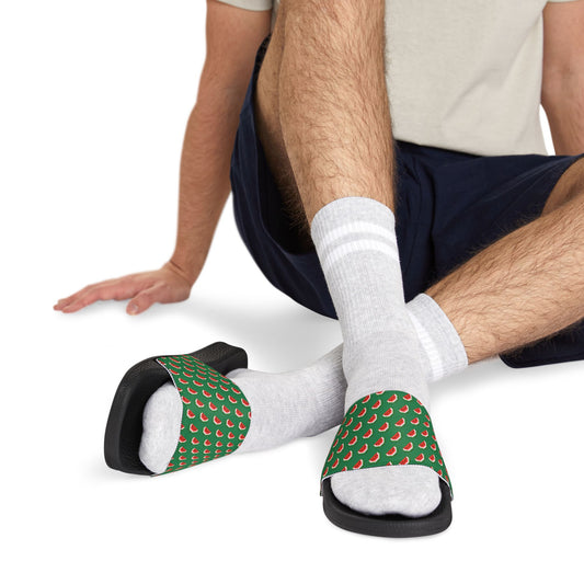 Man seated wearing Watermelon Green Slide Sandals with black soles and patterned straps over white socks.
