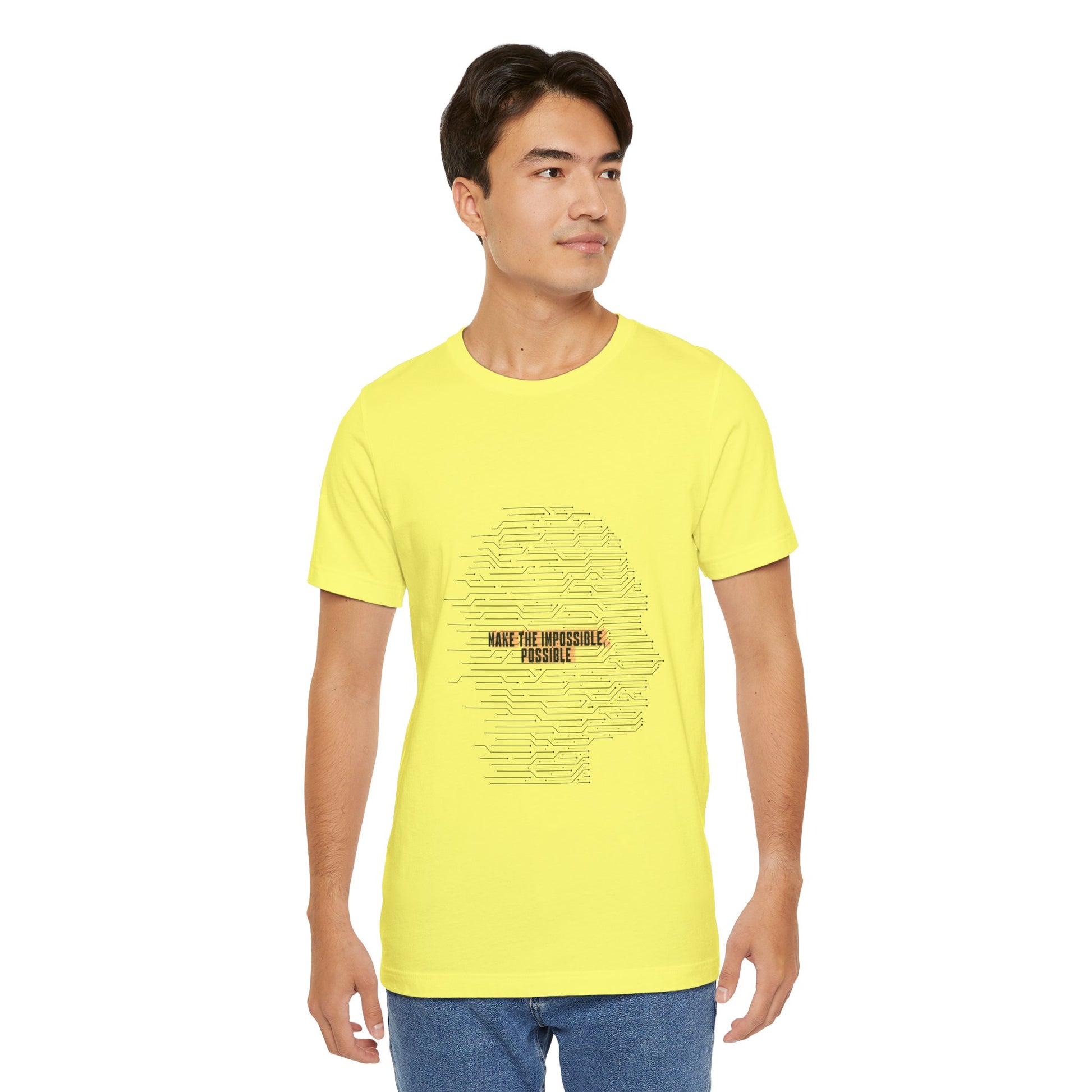 Man modeling yellow Make It Possible T-Shirt with bold futuristic text.