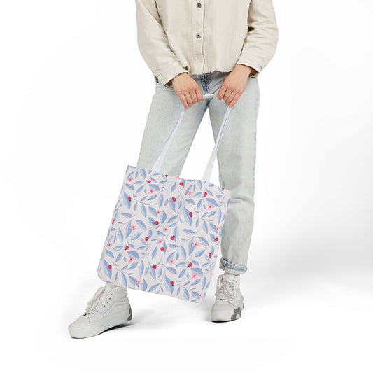 Person holding a Lady Bug Garden Tote Bag against white background.

