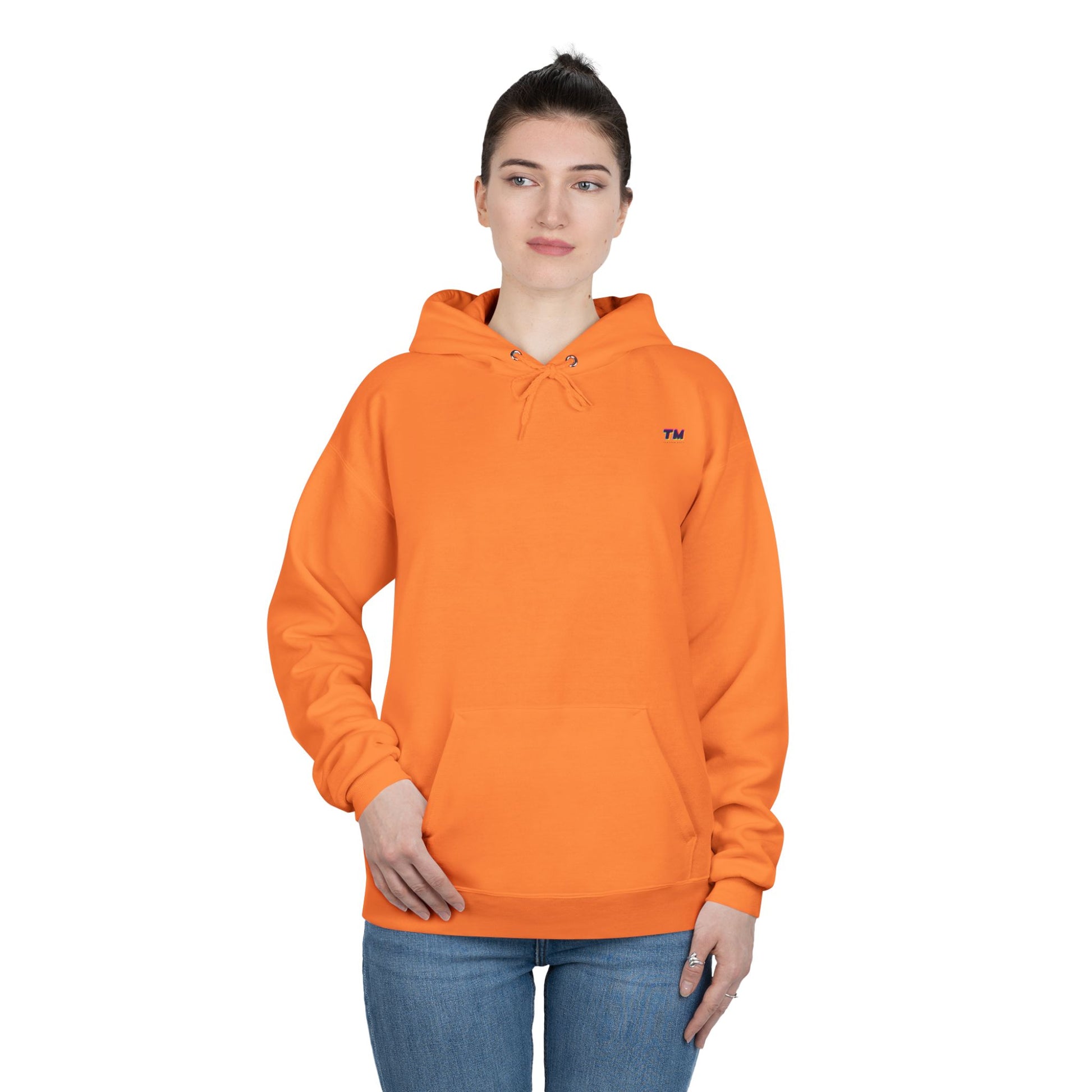 Woman wearing orange EcoSmart hoodie with hands in pockets.