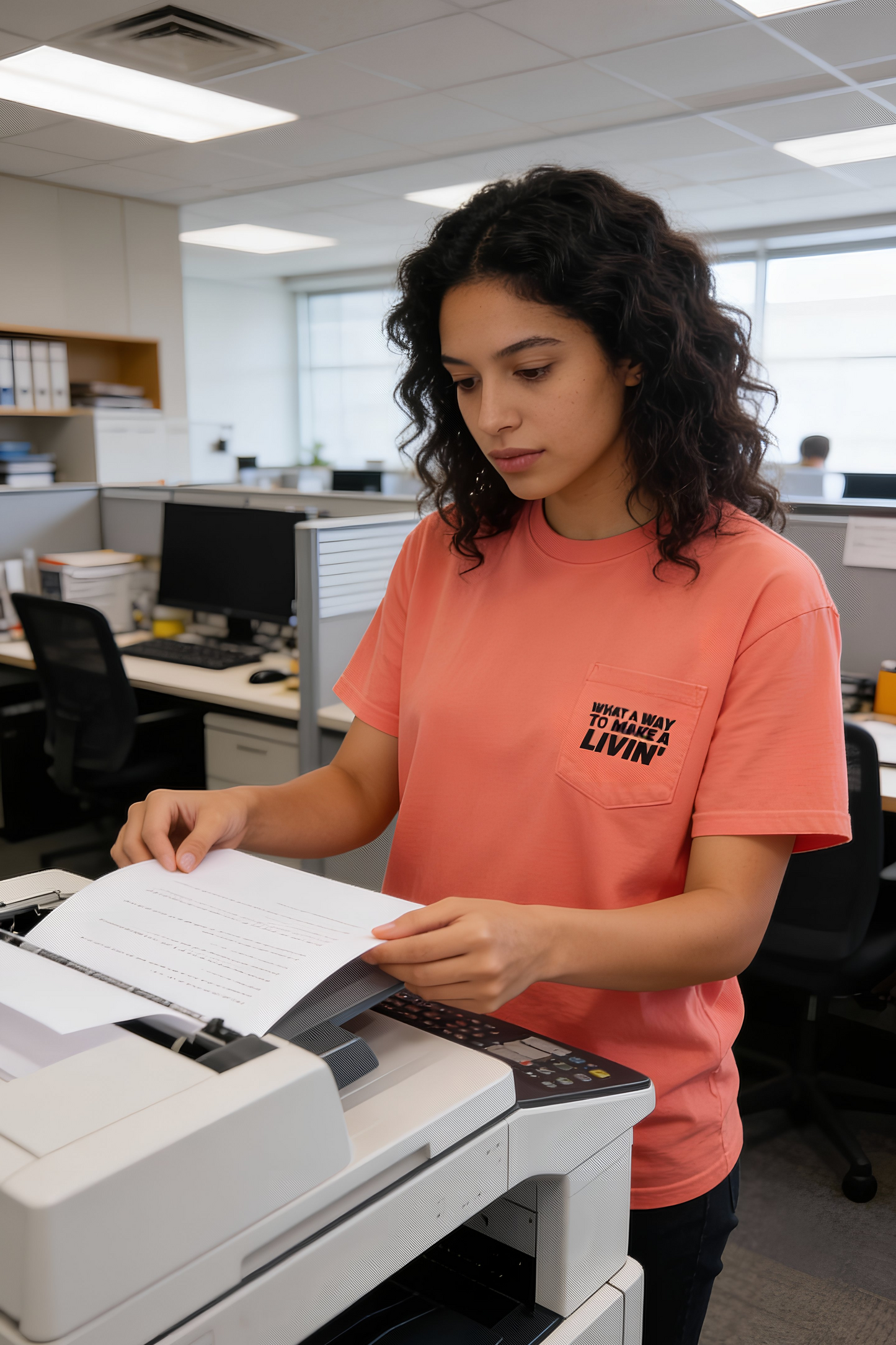 Person printing documents in an office wearing Neon Red Orange 9 to 5 pocket t-shirt