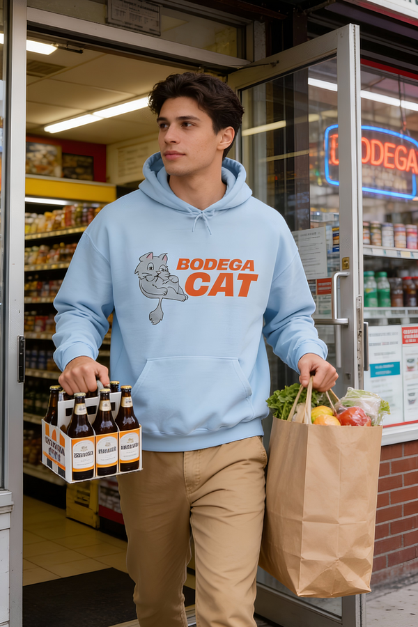 Man wearing light blue Bodega Cat hoodie outside New York bodega carrying groceries