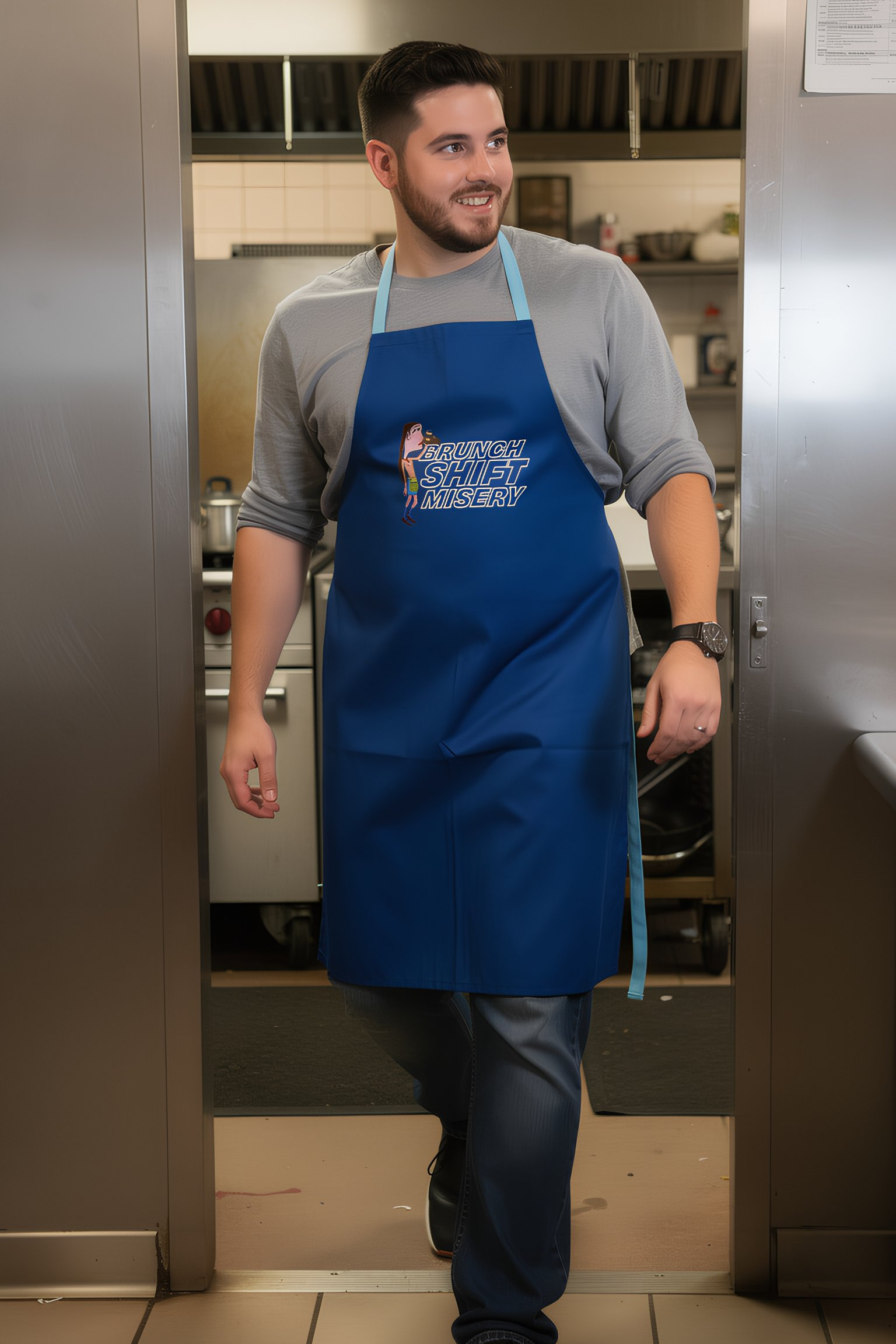 Man wearing blue Brunch Shift Misery apron in a commercial kitchen
