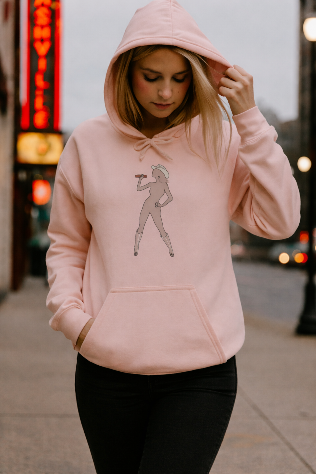 Light pink Bey Country Unisex Fleece Hoodie worn on city street with front graphic design visible