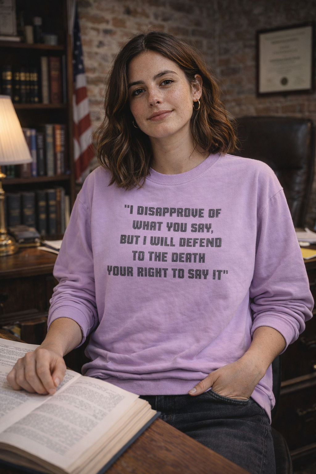 Woman wearing a teal Freedom of Speech sweatshirt in a studio portrait.