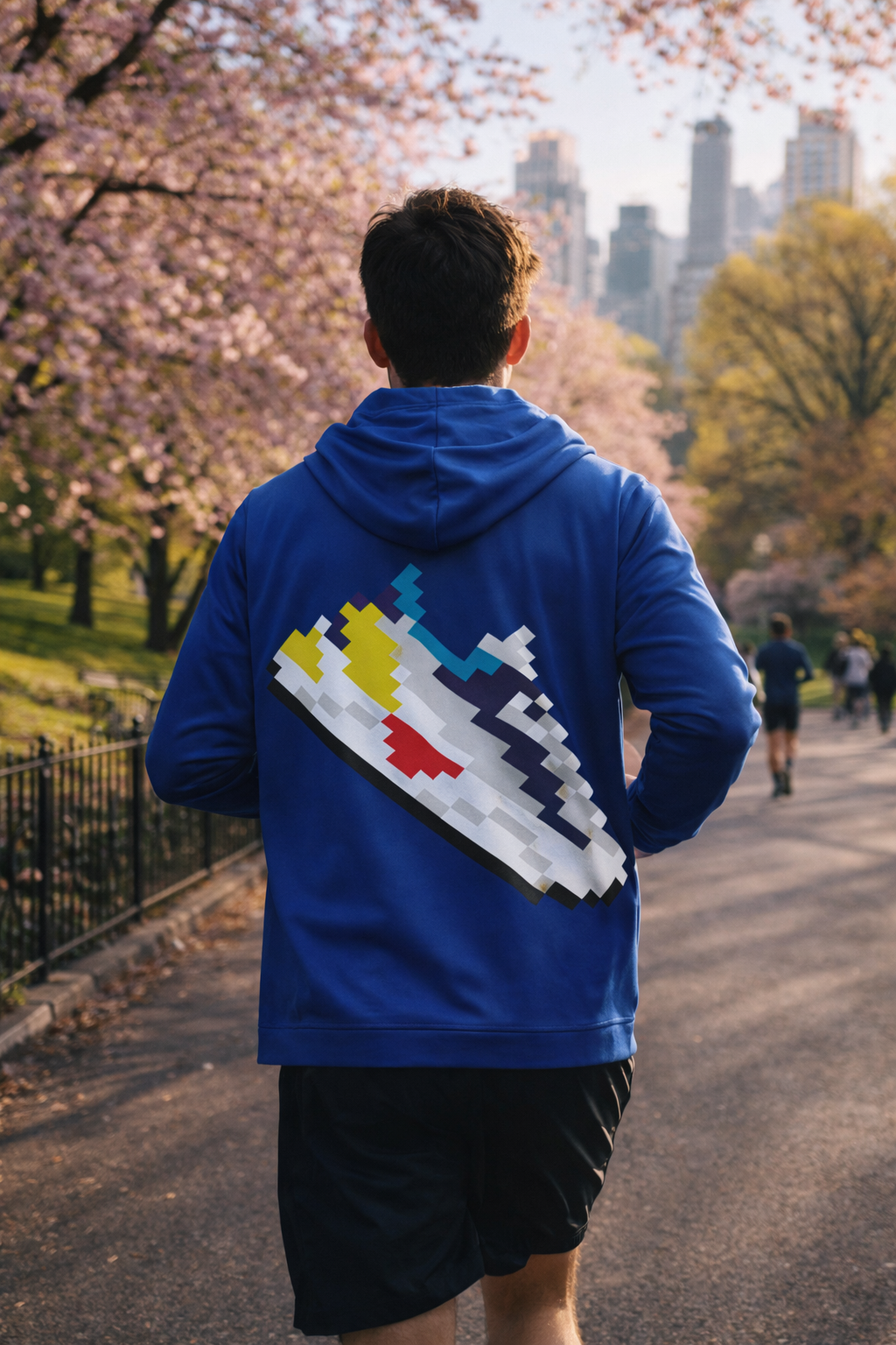 Back view of runner in Central Park wearing blue hooded sweatshirt with pixel art sneaker design