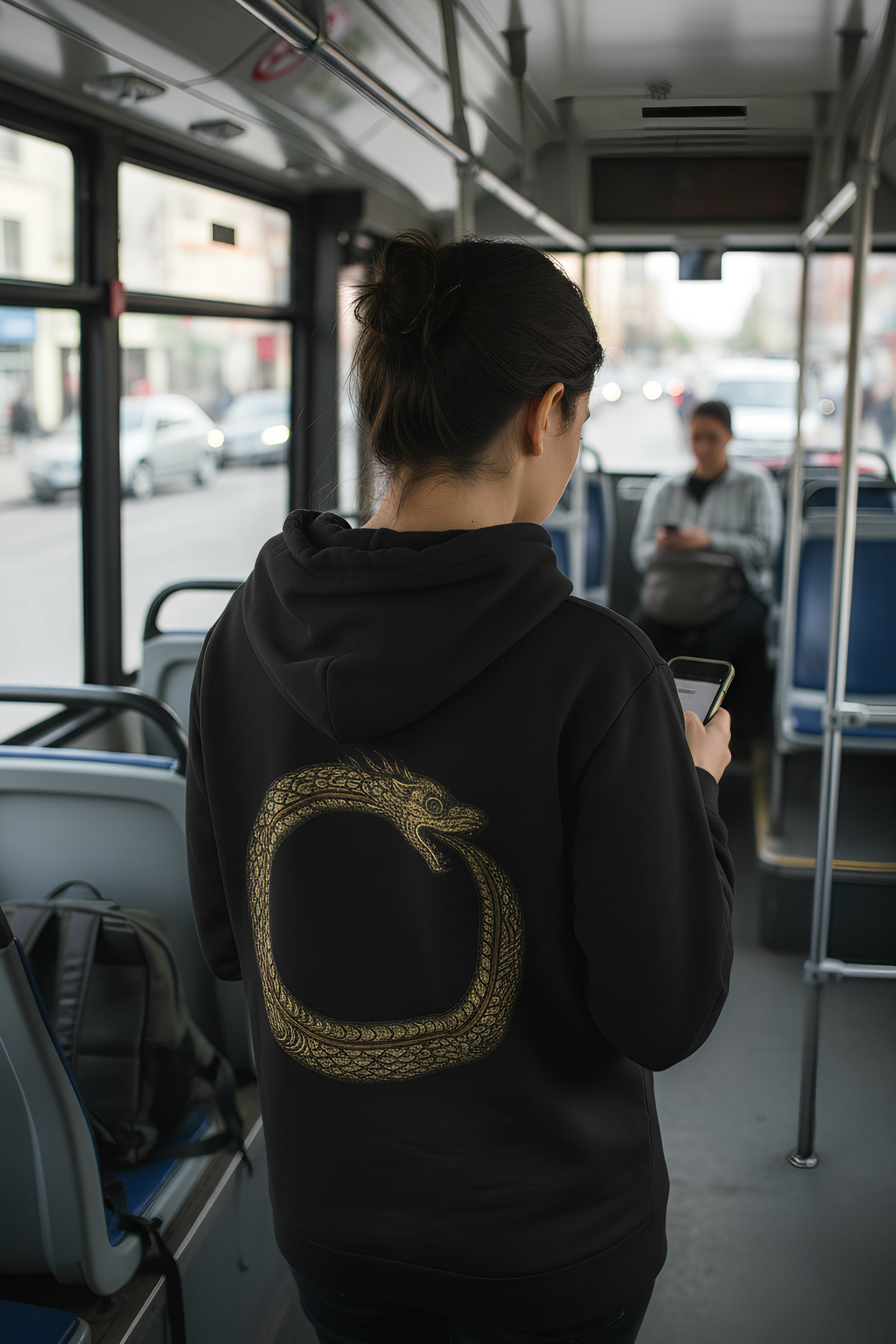 Person wearing black Good Karma hoodie inside a bus
