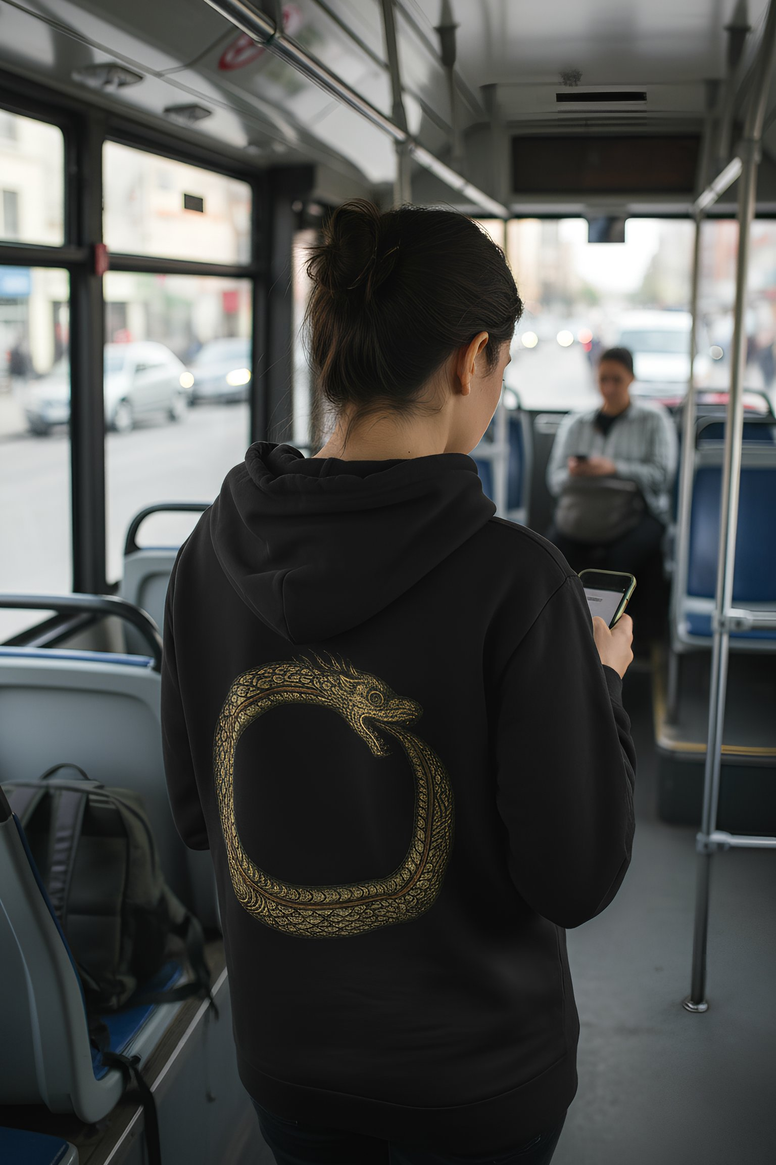 Person wearing black Good Karma hoodie inside a bus